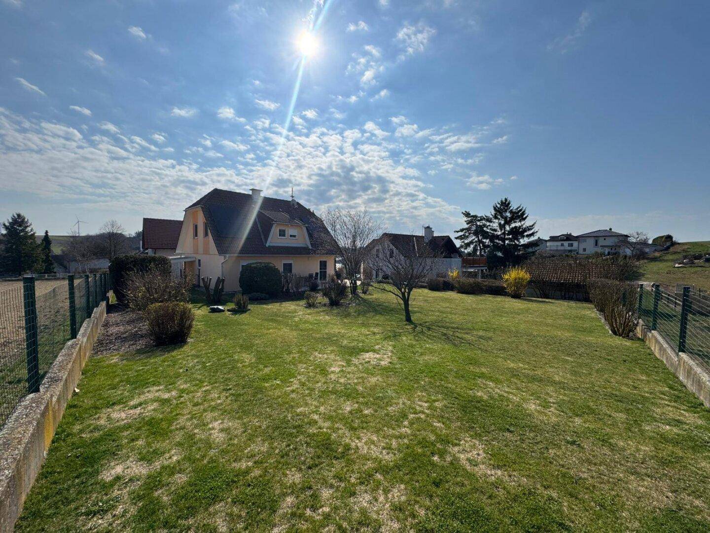 Großer, sonniger Garten hinter dem Haus mit viel Grünfläche und Blick auf die Umgebung.
