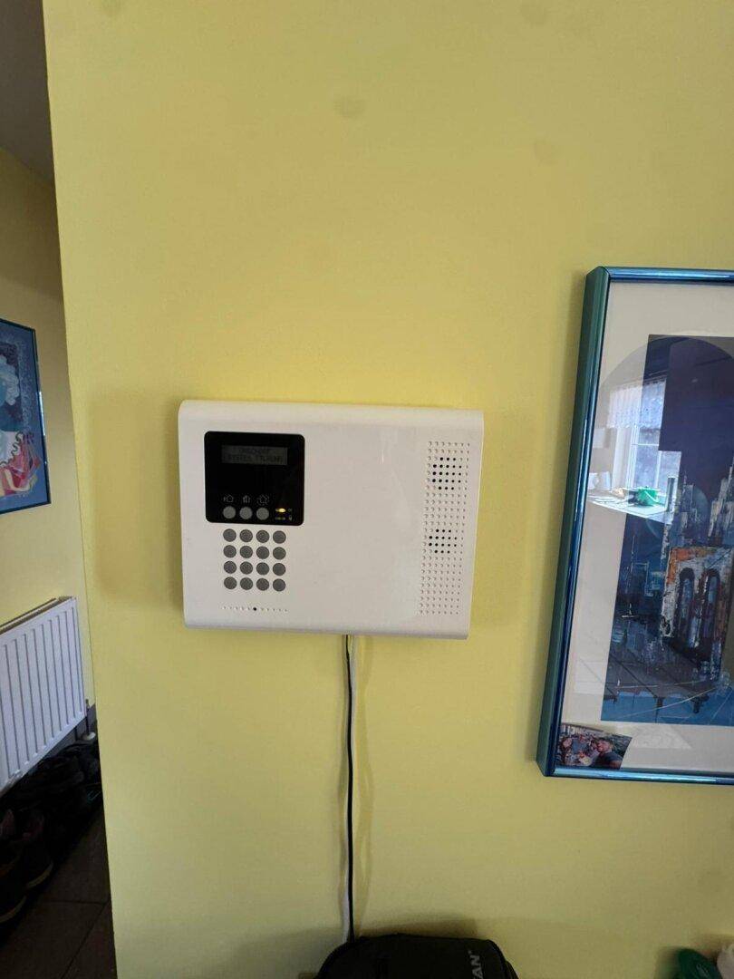 Sicherheitspanel an einer gelben Wand, zur Steuerung der Alarmanlage des Hauses.