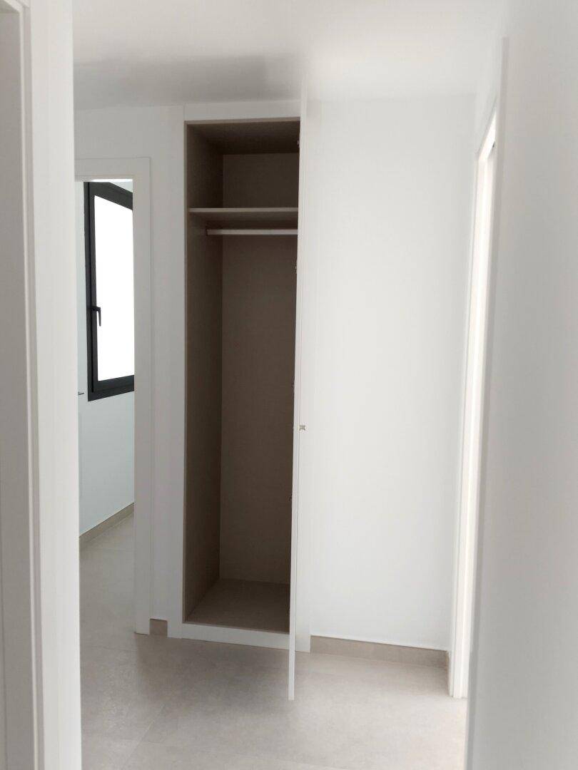 Heller Flur mit integriertem Wandschrank und Zugang zu weiteren Räumen.