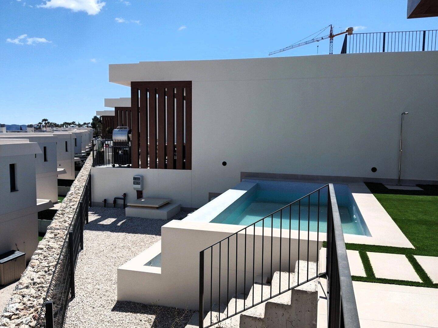 Außenbereich mit Pool, Treppe und Blick auf die benachbarten modernen Häuser.