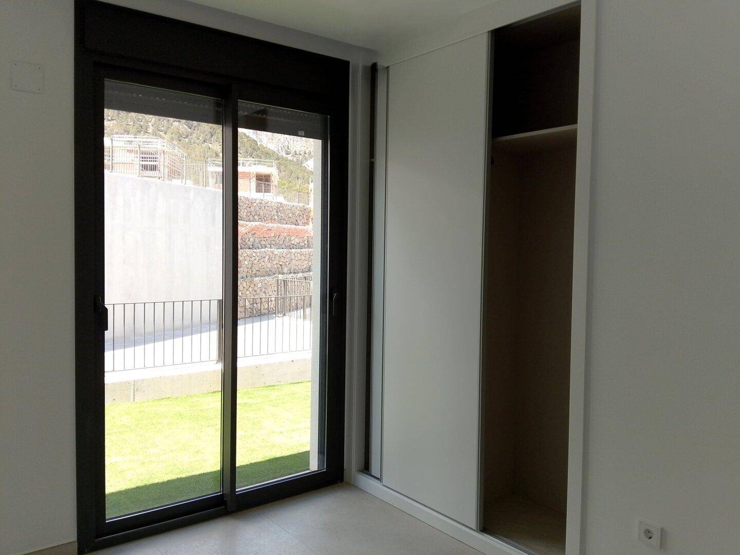 Schlafzimmer mit integriertem Schiebetürenschrank und Blick auf die umliegenden Berge.