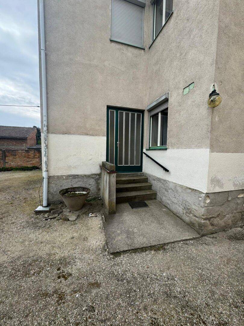 Seitlicher Eingangsbereich des Gebäudes mit Treppe und Rampe.