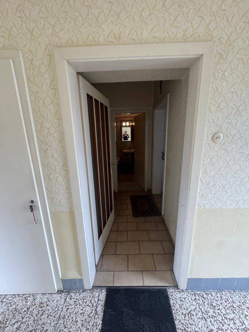 Flur mit Durchgang zu weiteren Räumen, ausgestattet mit Fliesenboden.