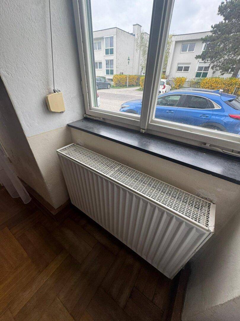 Fenster mit Heizkörper darunter, bietet einen Blick auf die Umgebung.