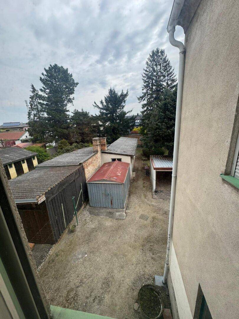 Blick von oben auf den Hinterhof mit mehreren Garagen und Bäumen.