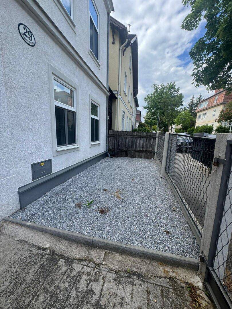 Vorderansicht des Gebäudes mit einer kleinen Kiesfläche und der Hausnummer 29 neben der Straße.