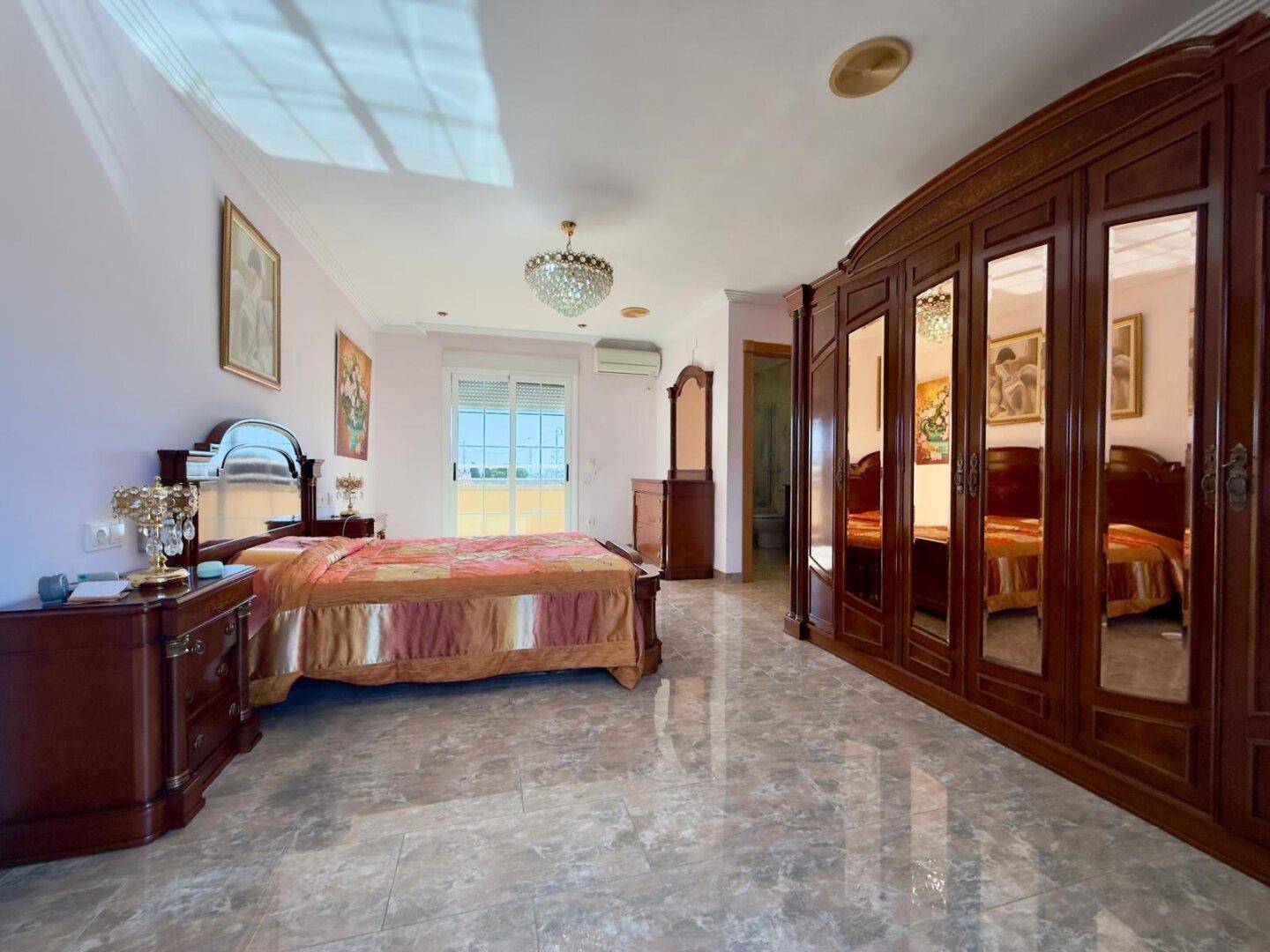 Geräumiges Schlafzimmer mit großem Spiegelschrank und viel Stauraum.