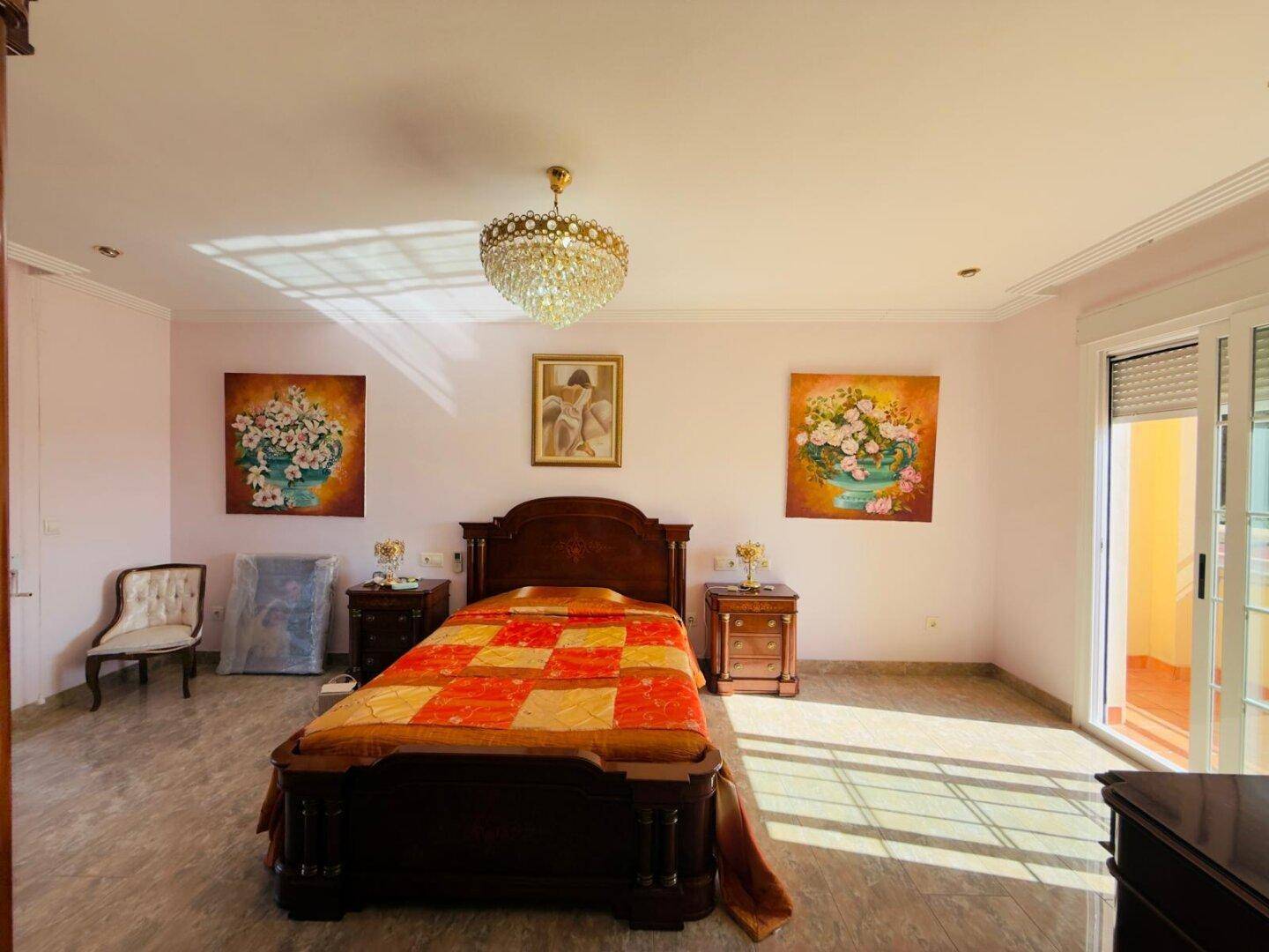 Helles Schlafzimmer mit großem Bett, Spiegelschrank und Zugang zum Balkon.