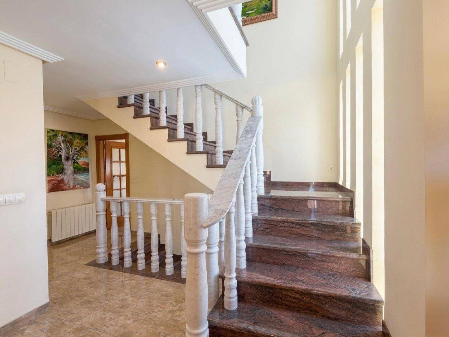 Detailansicht der Marmortreppe im Flur, die von Tageslicht erhellt wird.