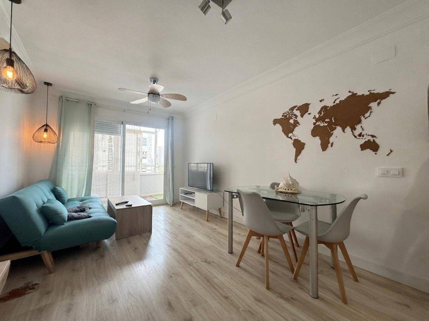 Heller Wohn- und Essbereich mit modernem Sofa, Esstisch und Zugang zum Balkon.