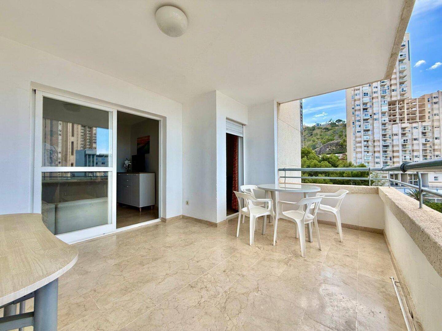 Geräumiger Balkon mit Zugang zum Innenbereich und Blick auf die städtische Umgebung.