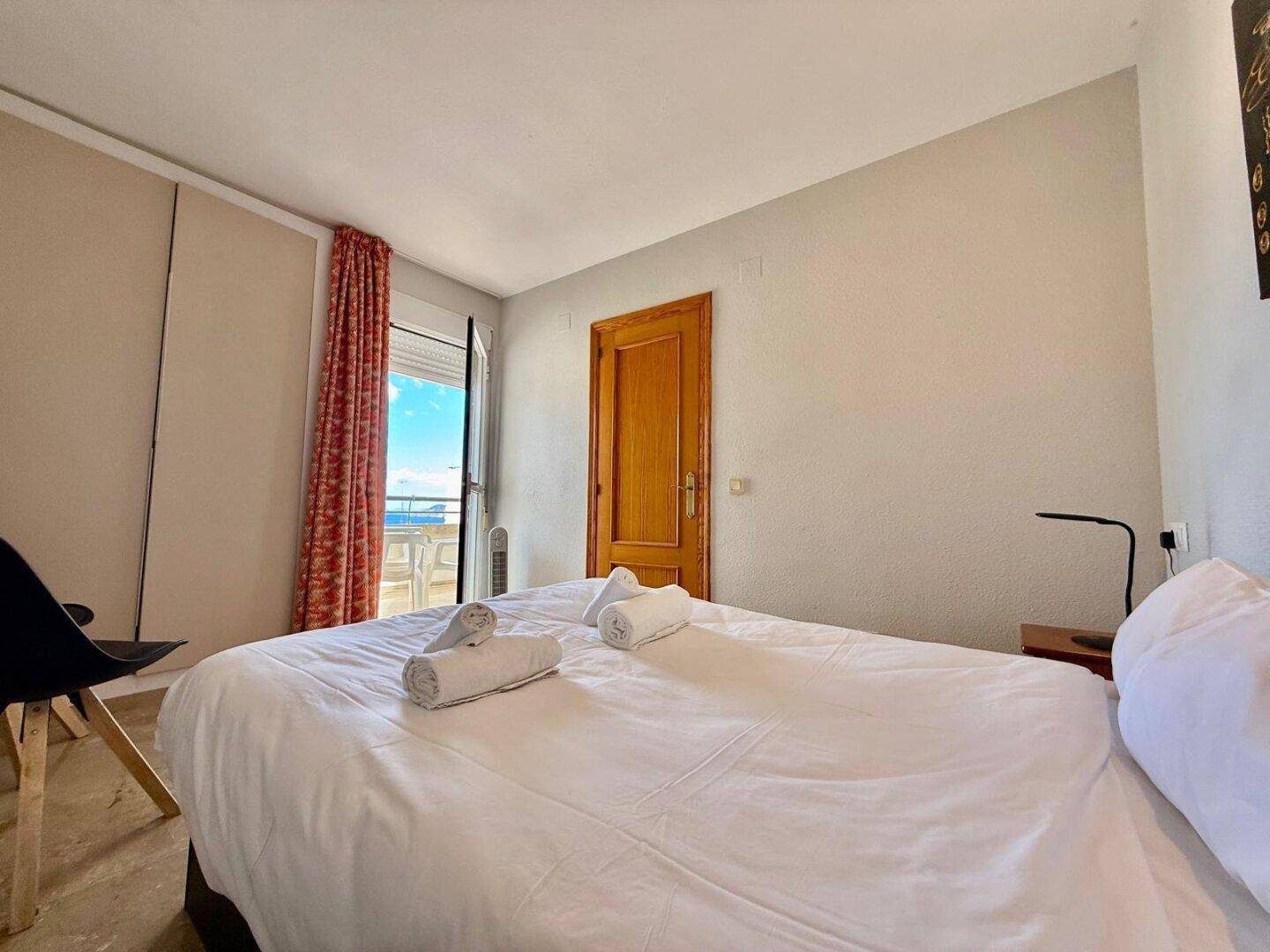 Schlafzimmer mit Doppelbett und direktem Zugang zum Balkon mit Meerblick.