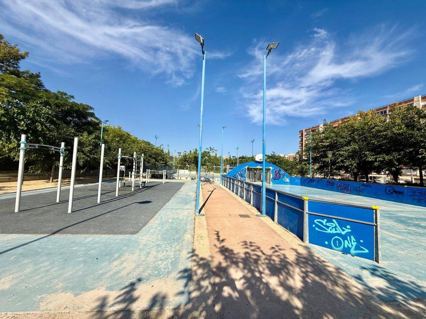 Outdoor-Fitnessbereich neben einem Sportplatz, bietet Möglichkeiten für körperliche Betätigung.