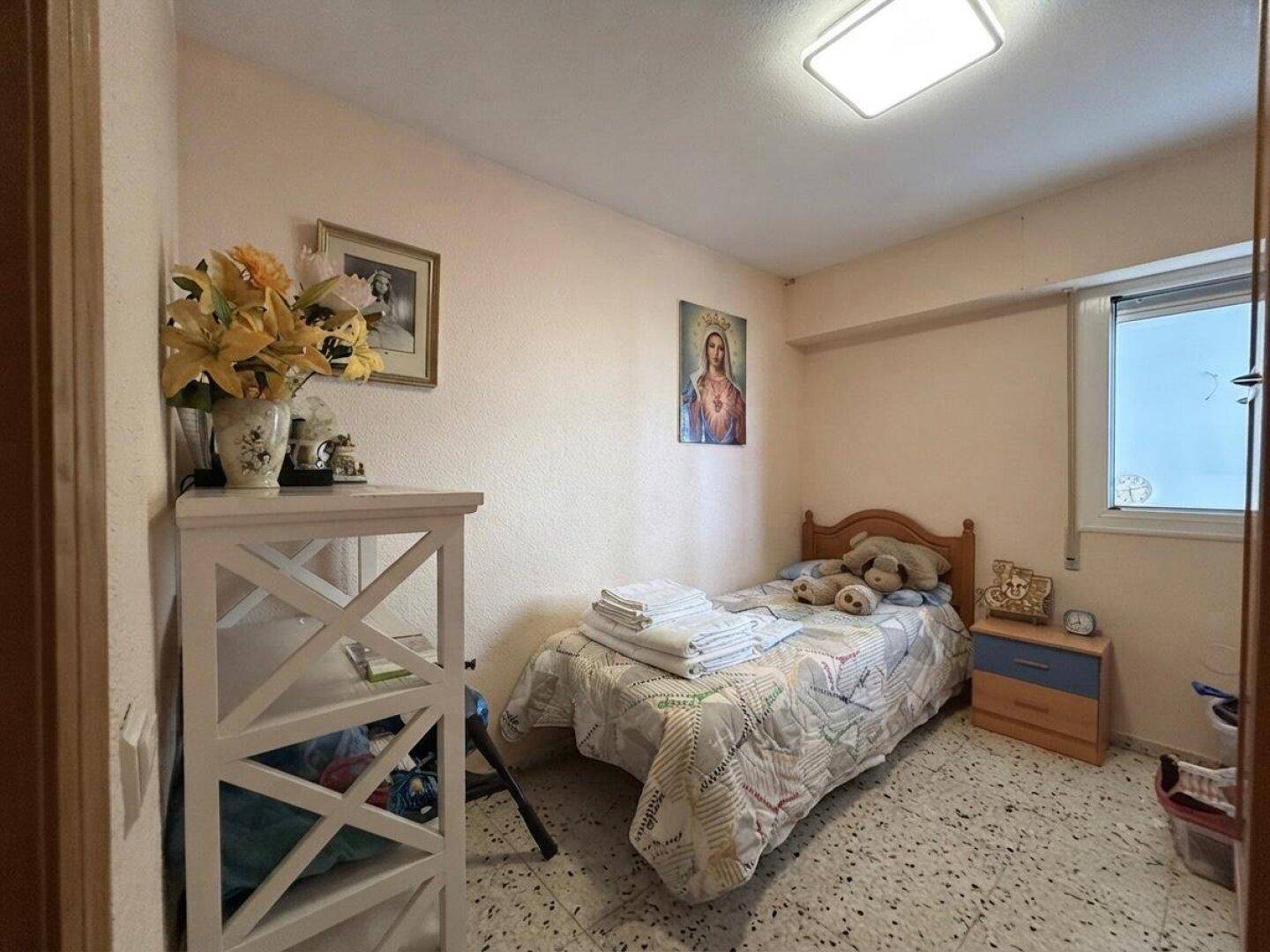 Gemütliches Schlafzimmer mit Einzelbett, Nachttisch und Fenster, ideal für Gäste.