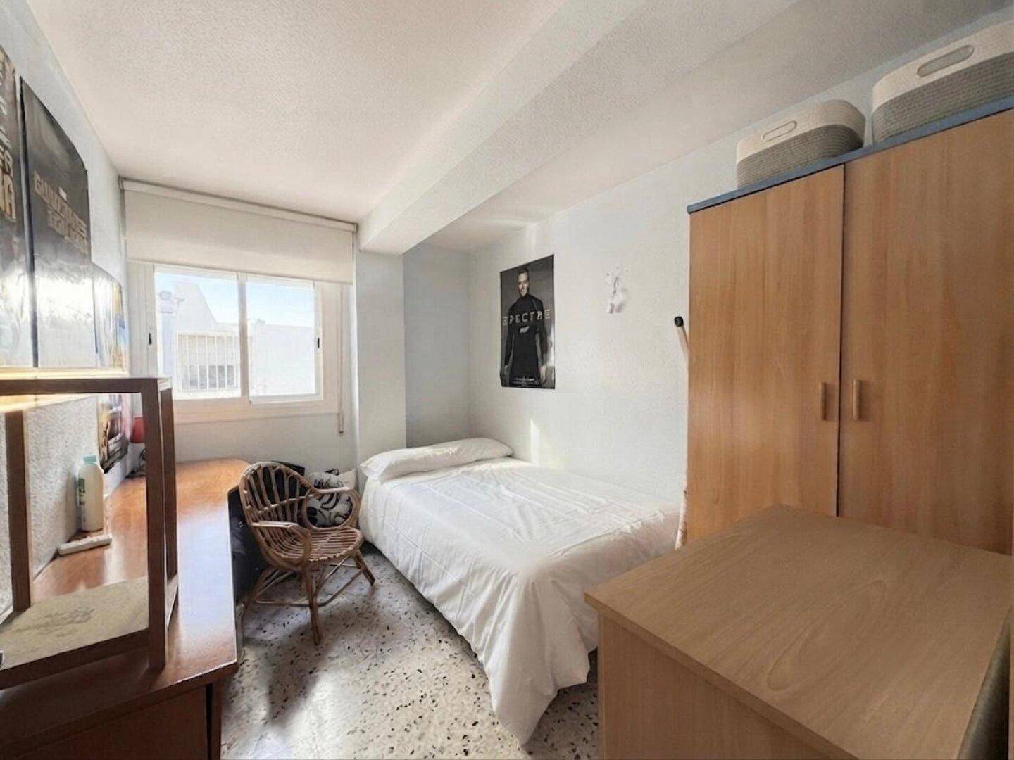 Jugendzimmer mit Einzelbett, Kleiderschrank und Fenster, bietet eine helle Atmosphäre.