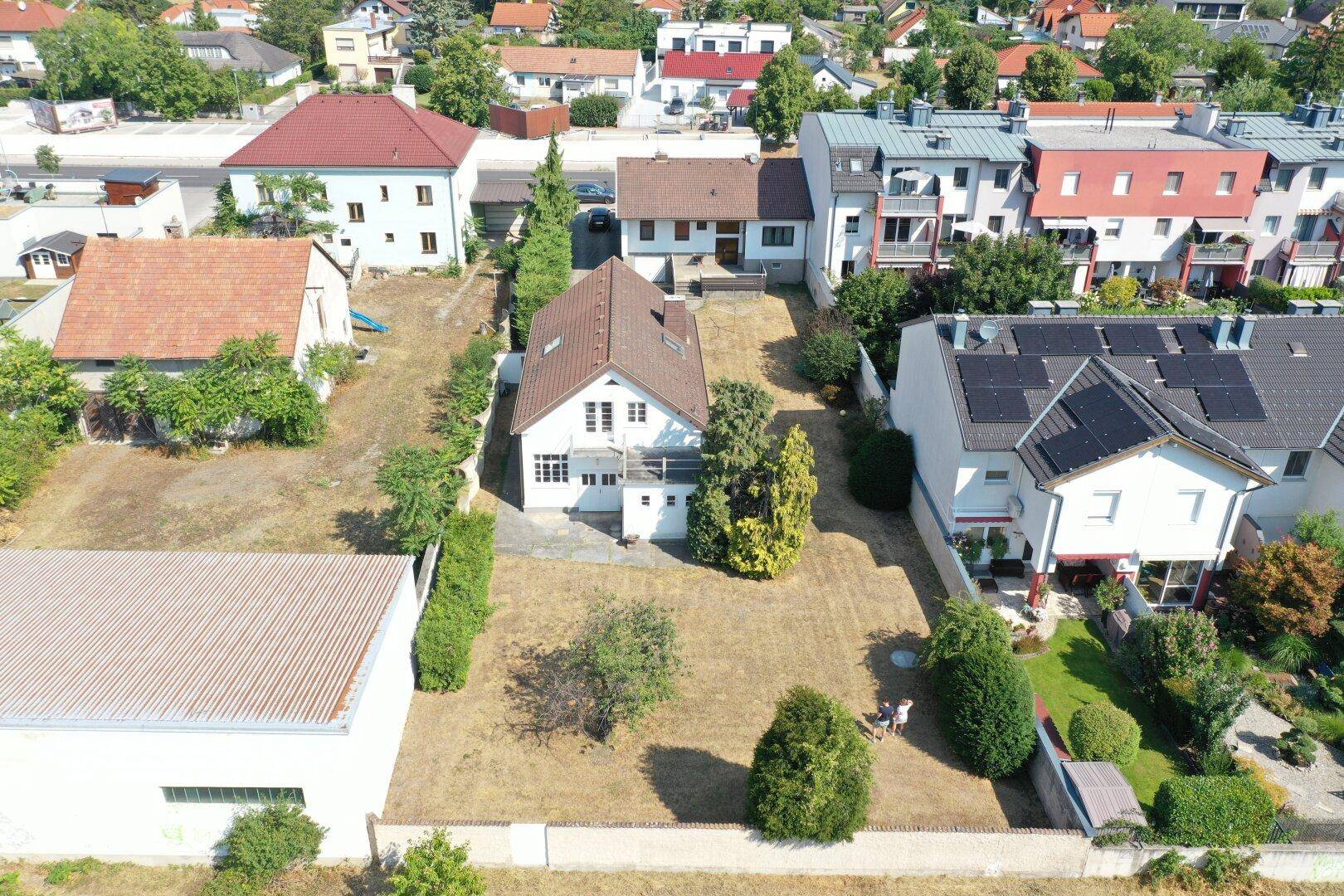 Weitläufige Luftaufnahme des Hauses mit großem Grundstück und umliegender Wohnbebauung.