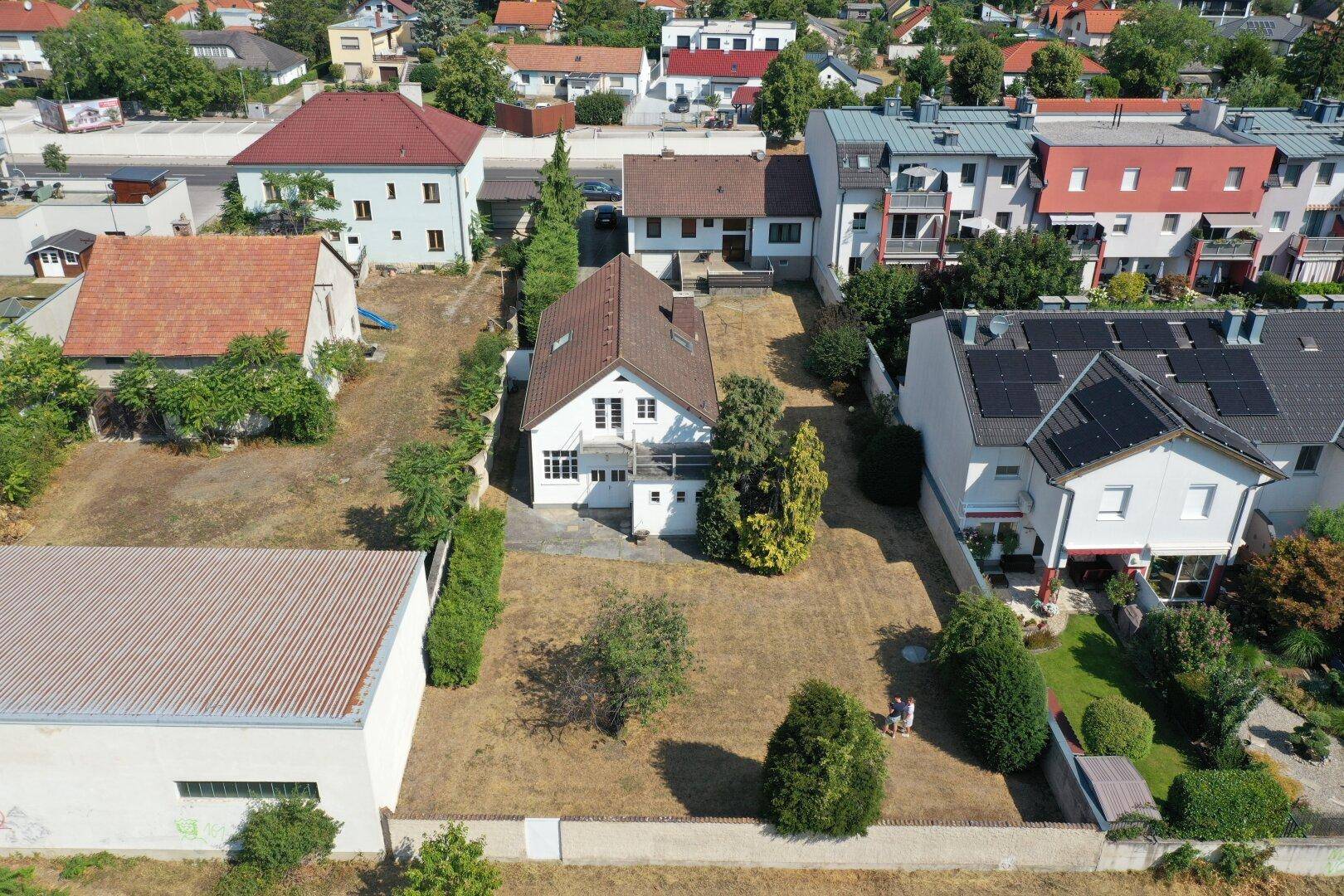 Weitläufige Luftaufnahme des Hauses mit großem Grundstück und umliegender Wohnbebauung.