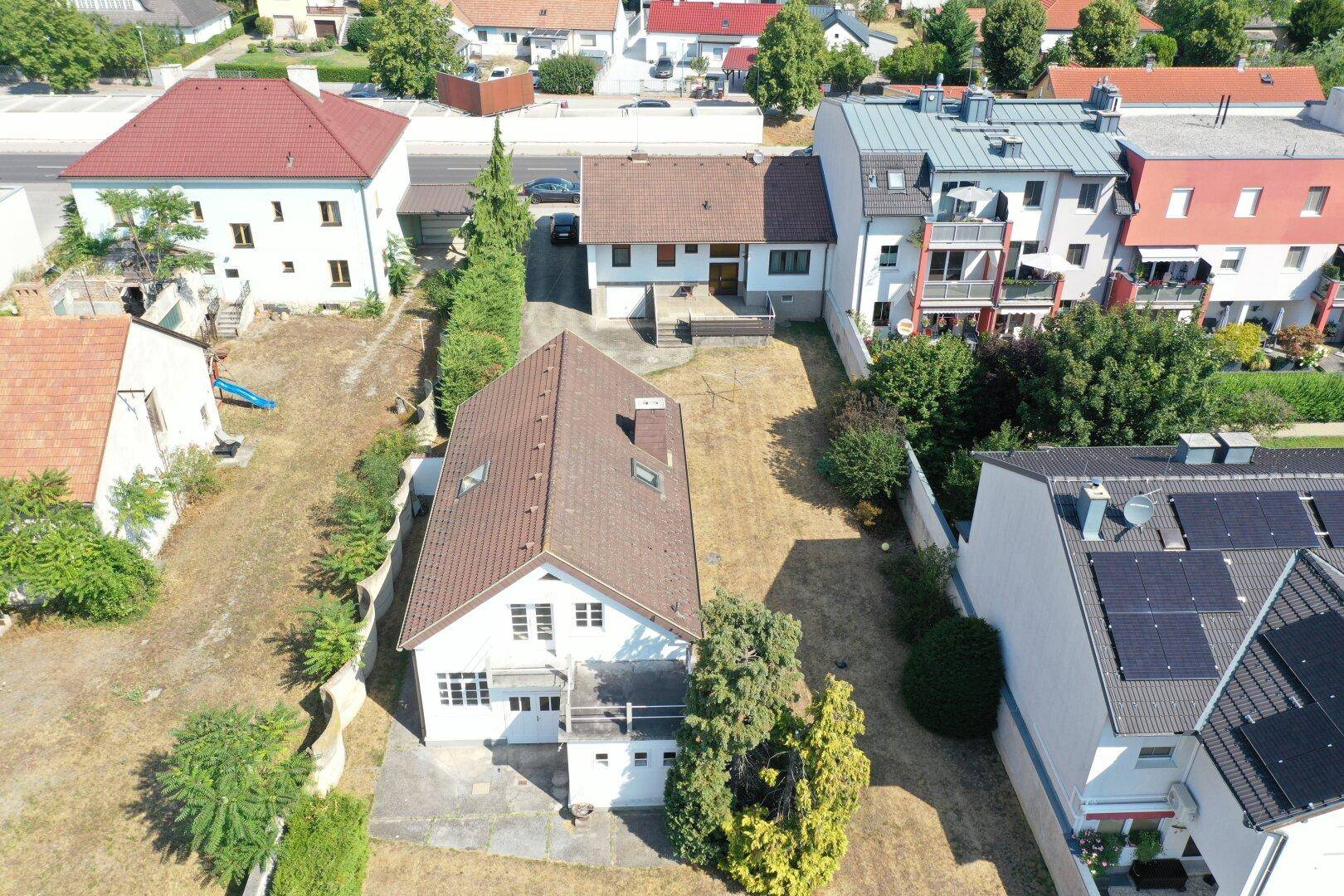 Luftaufnahme des Hauses mit langem, trockenem Garten und angrenzenden Nachbargrundstücken.
