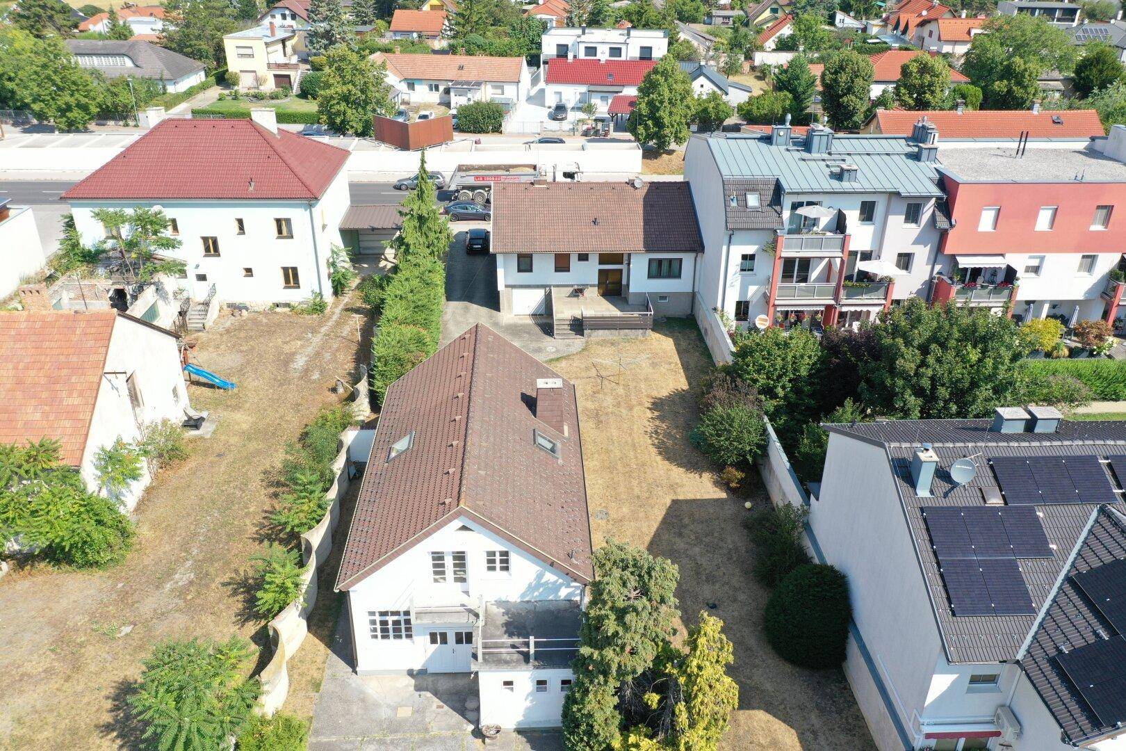 Luftaufnahme des Hauses mit langem, trockenem Garten und angrenzenden Nachbargrundstücken.