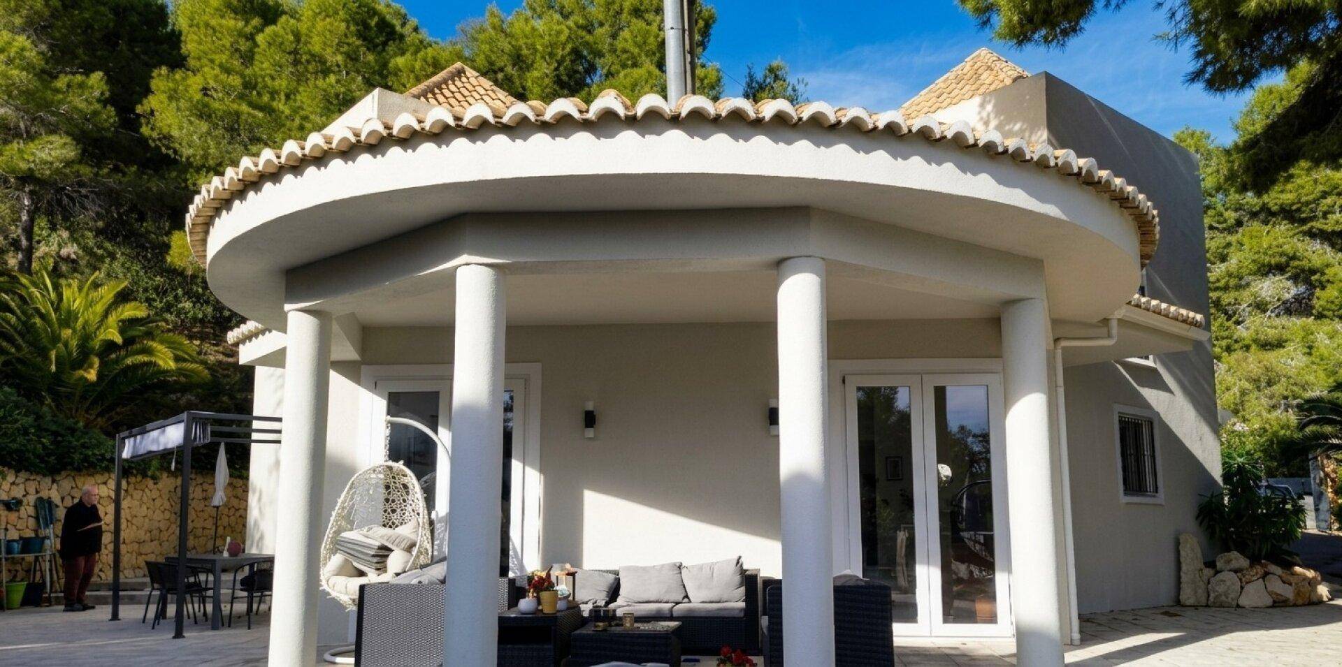 Elegante überdachte Terrasse mit Säulen und Sitzgelegenheiten im Freien.
