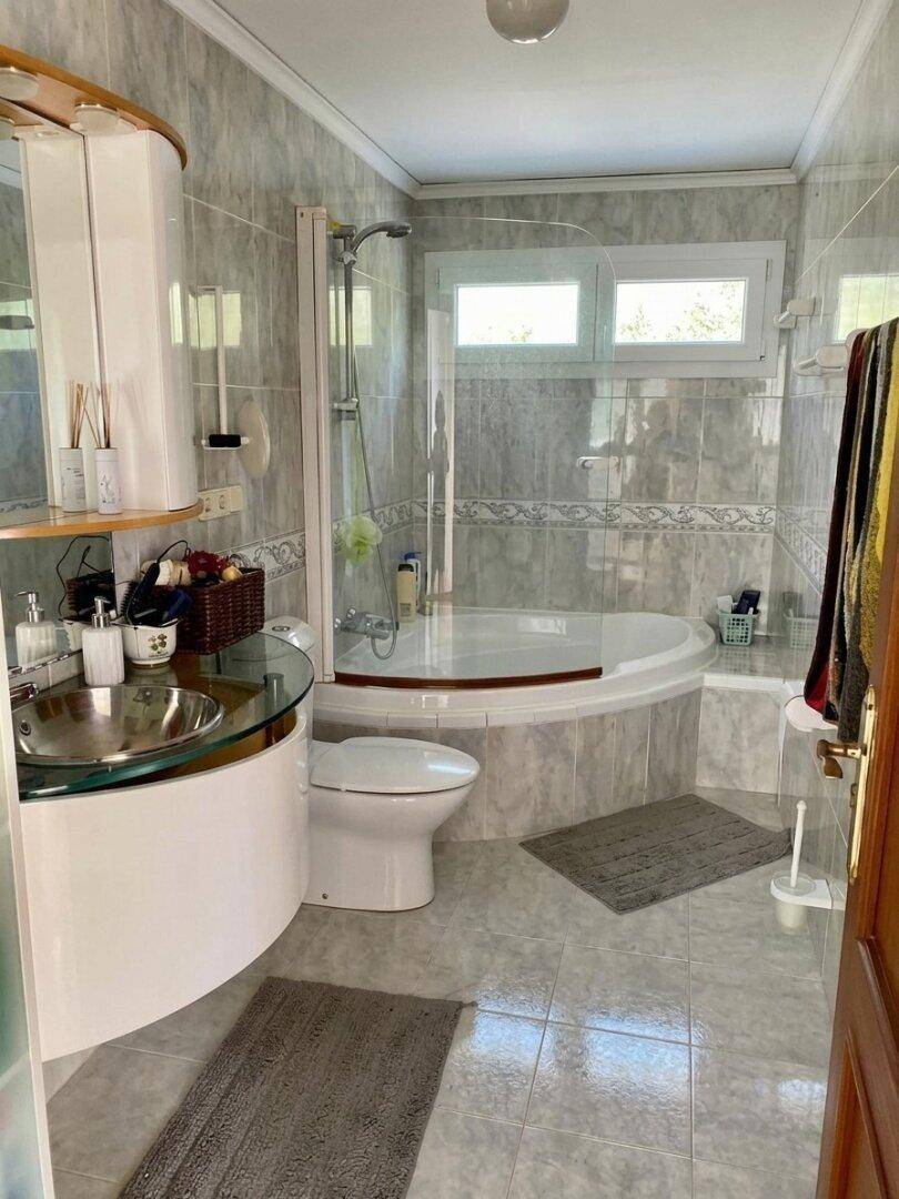 Badezimmer mit Eckbadewanne, Dusche und modernem Waschtisch.