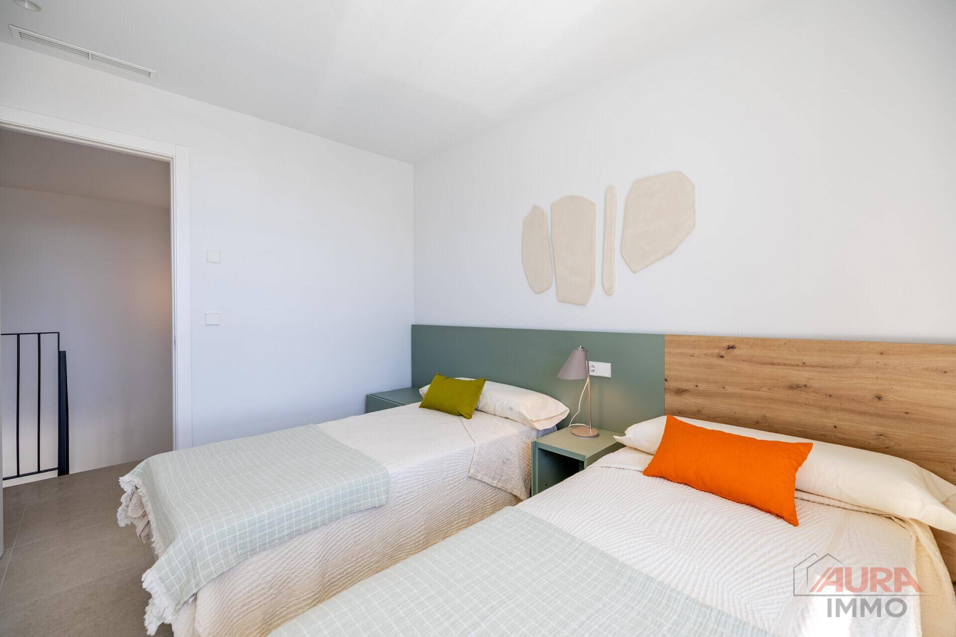 Helles Gästezimmer mit zwei Einzelbetten und moderner, schlichter Einrichtung.