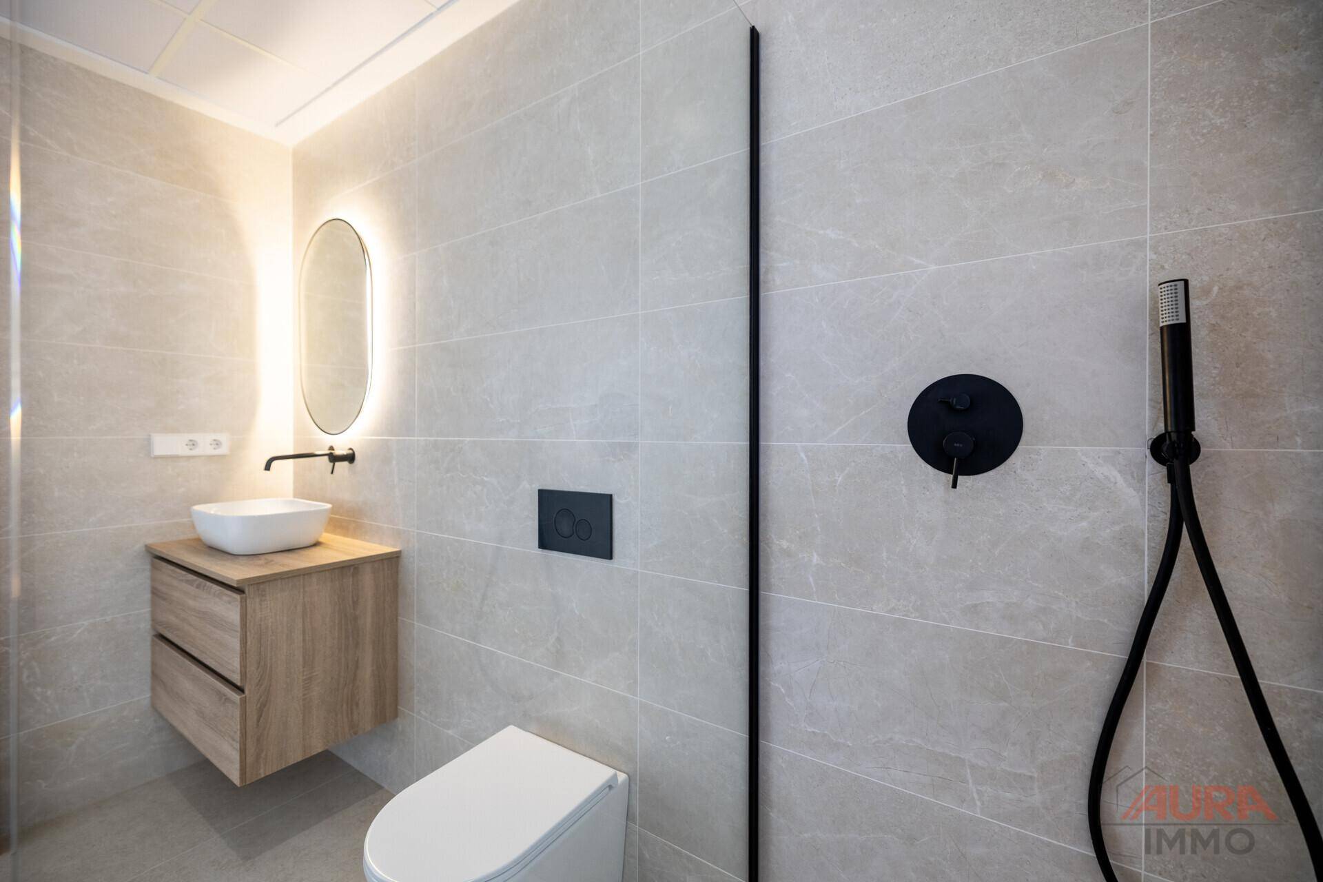 Elegantes Badezimmer mit begehbarer Dusche, modernem Waschtisch und minimalistischem Design.