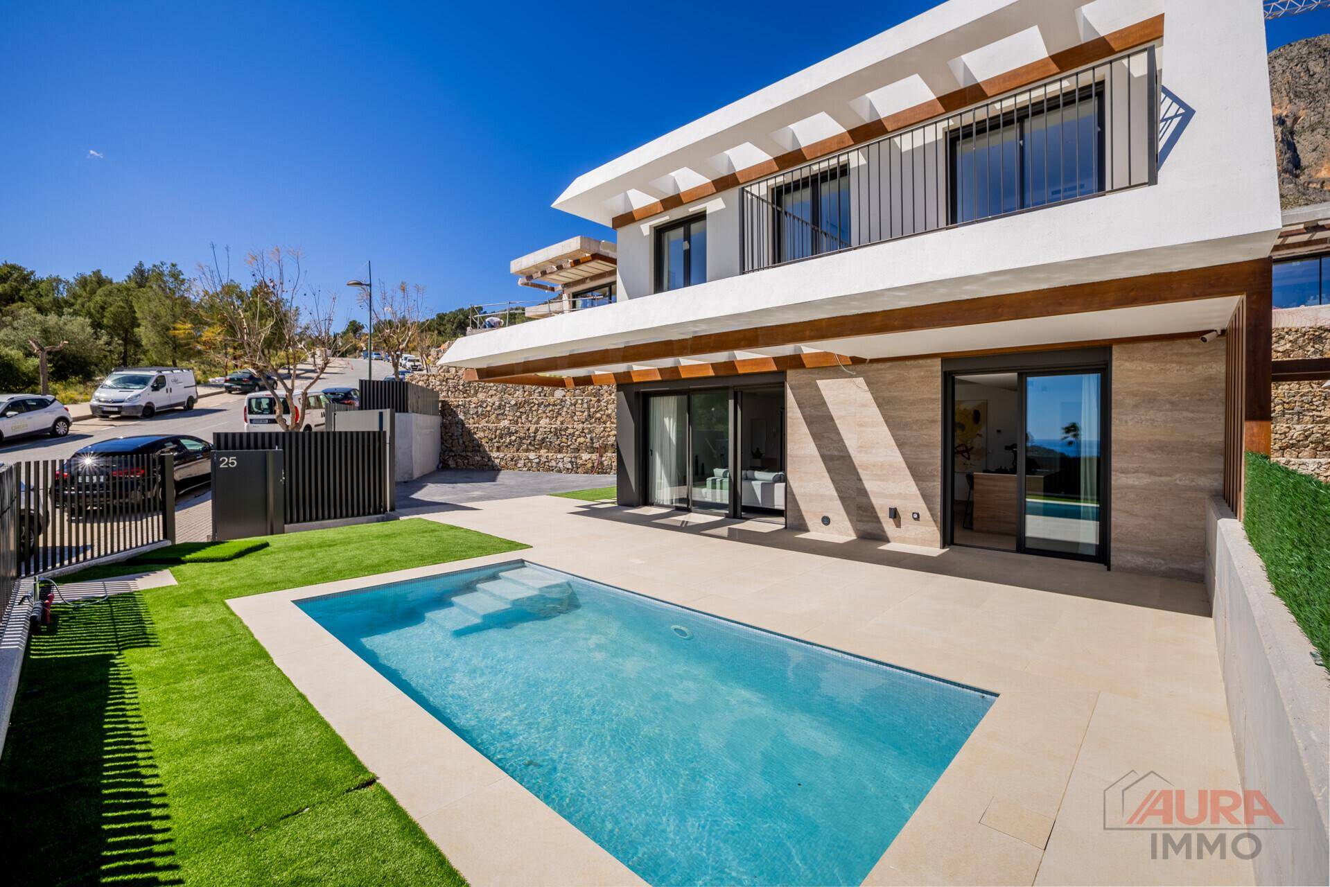 Ansicht der modernen Villa mit Poolbereich, Auffahrt und umliegender Landschaft.