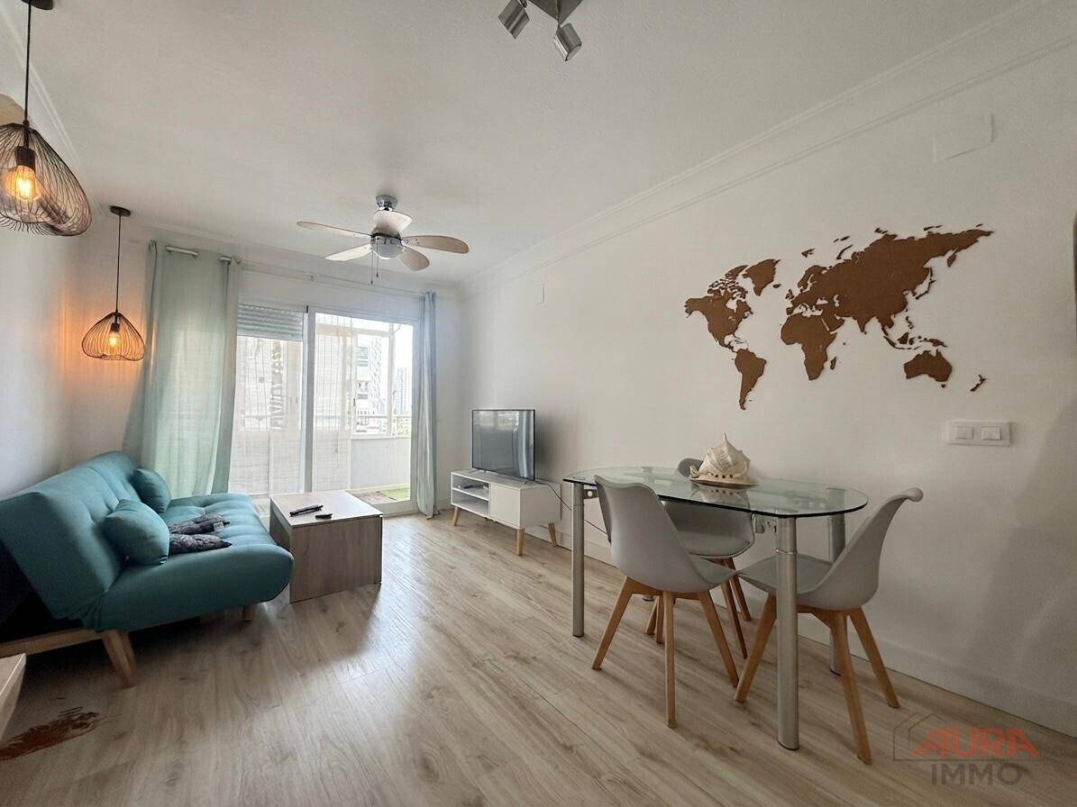 Heller Wohn- und Essbereich mit modernem Sofa, Esstisch und Zugang zum Balkon.