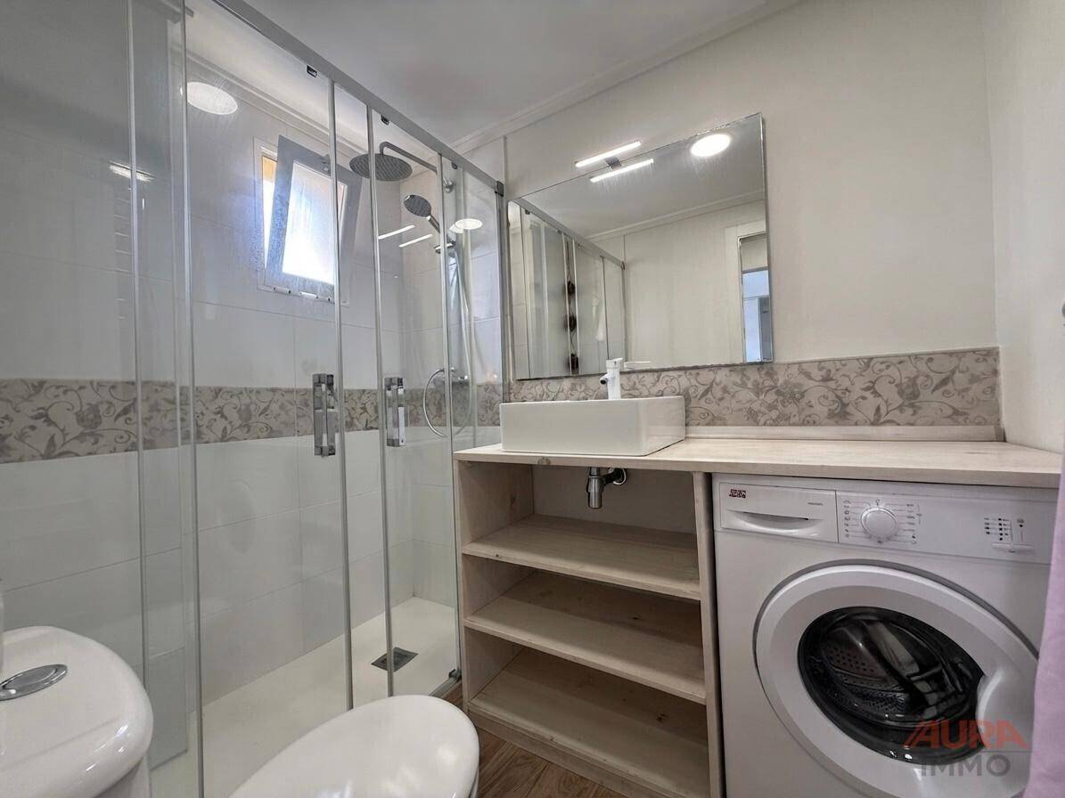Modernes Badezimmer mit begehbarer Dusche, Einzelwaschbecken und Holz-Arbeitsplatte.