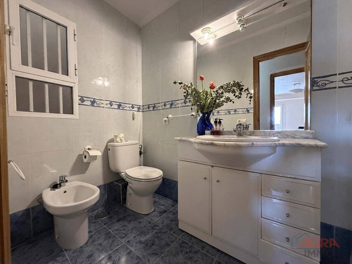 Badezimmer mit blauen und weißen Fliesen, Waschtisch, Toilette und einem Bidet.