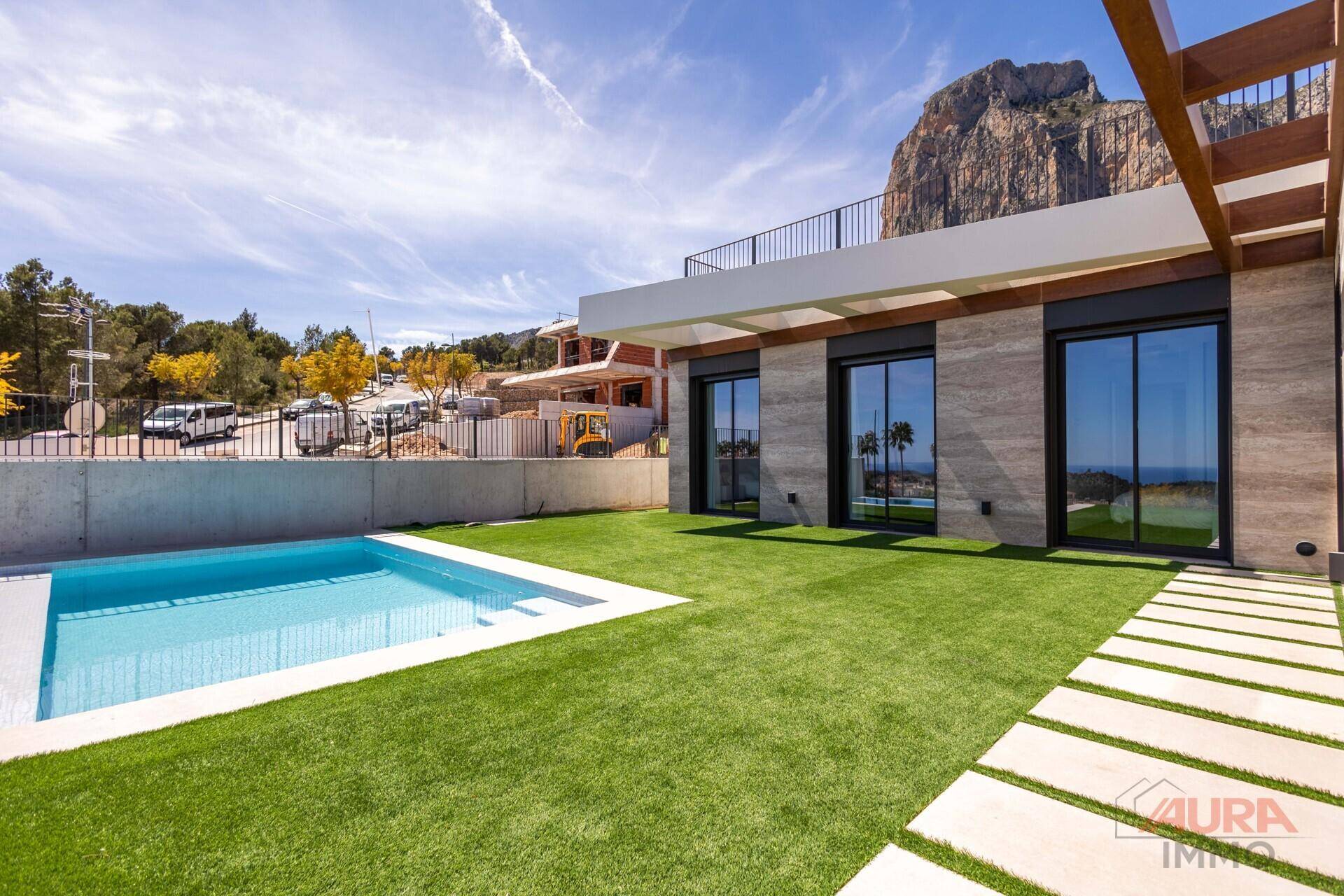 Moderne Villa mit Pool, Kunstrasenfläche und beeindruckendem Blick auf die Felslandschaft.