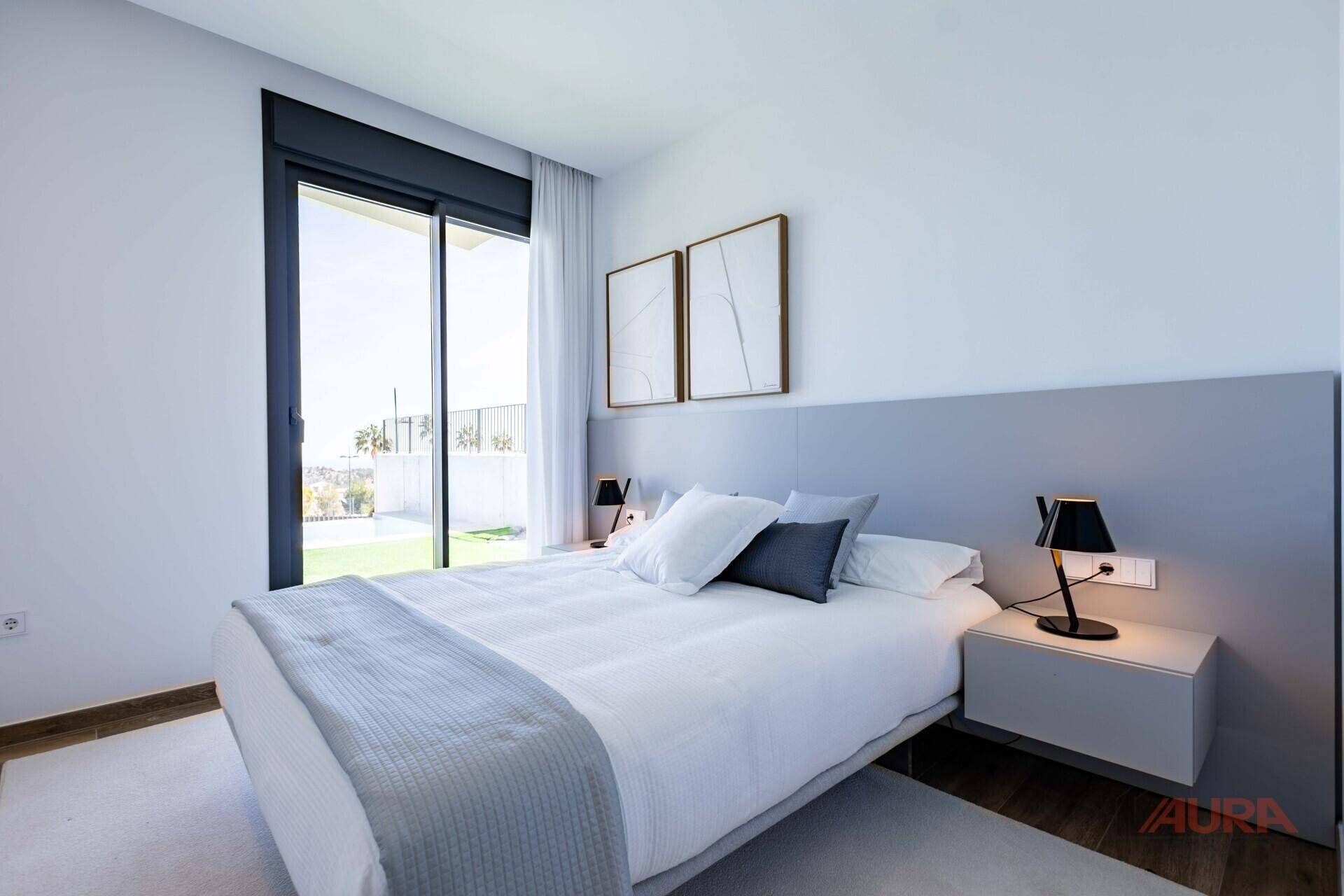Modernes Schlafzimmer mit großem Schiebefenster und direktem Zugang zum grünen Außenbereich.