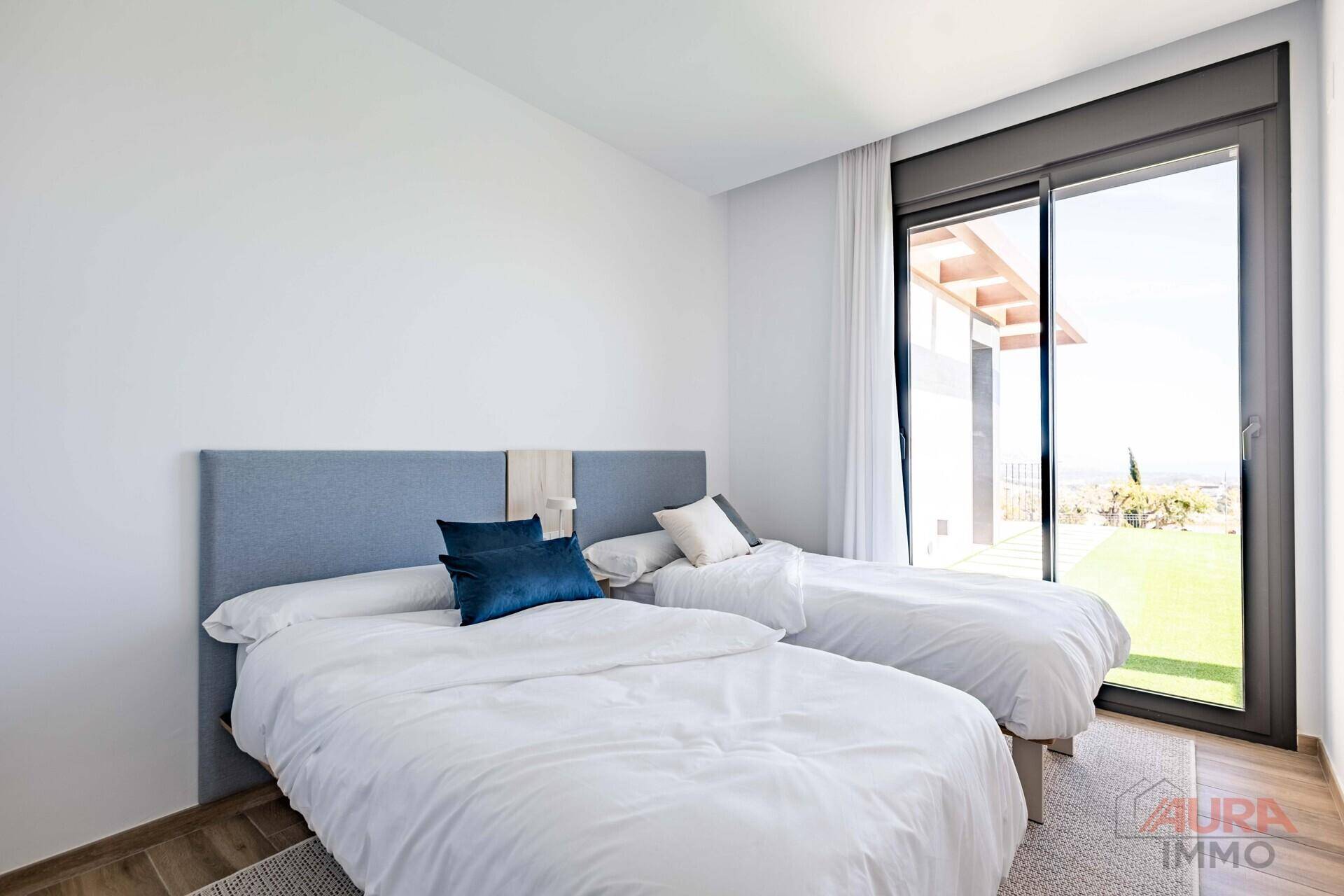 Helles Schlafzimmer mit zwei Einzelbetten und großem Fenster mit Ausblick auf die Umgebung.