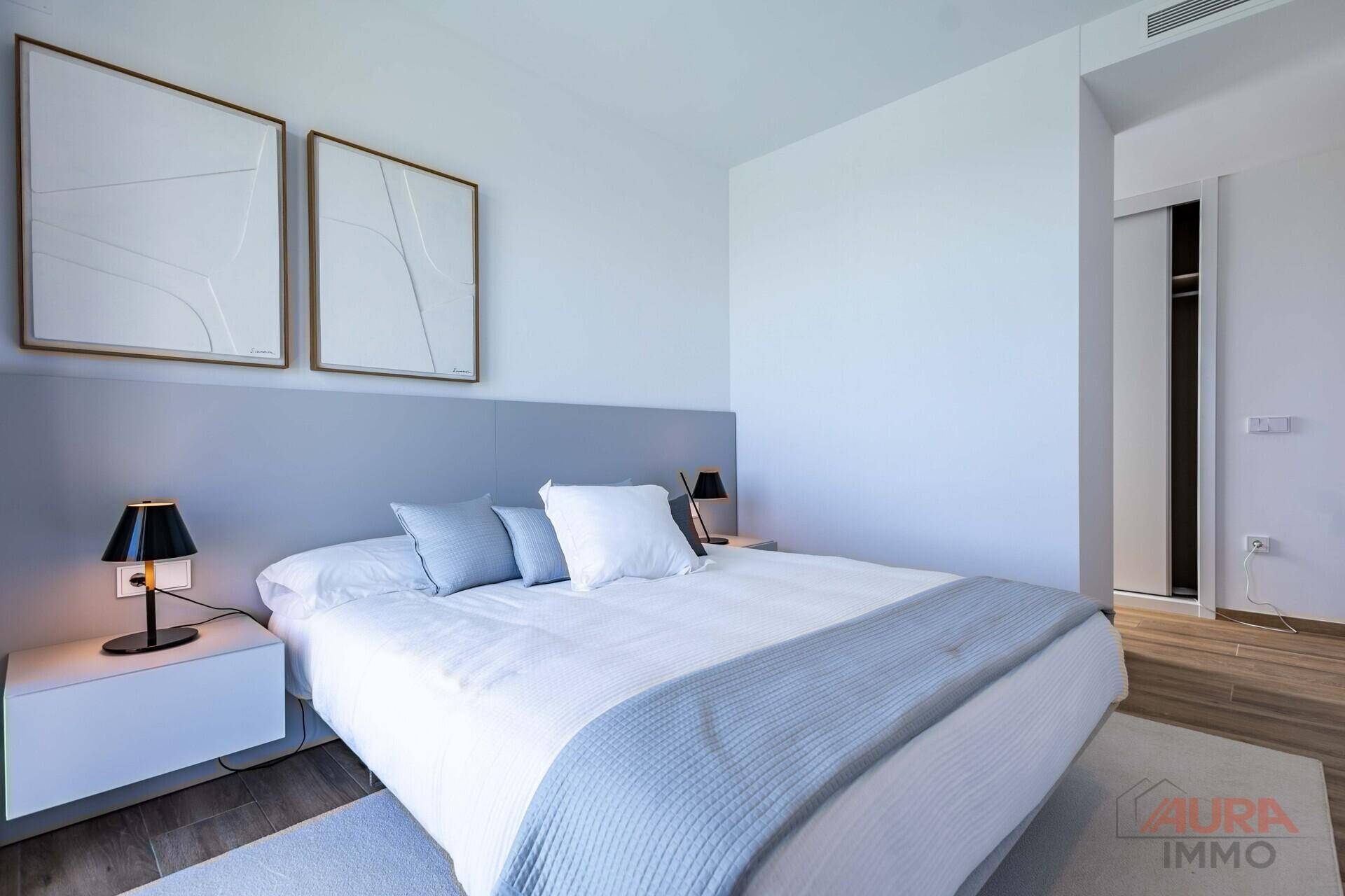 Helles Schlafzimmer mit modernem Design, großem Bett und integriertem Kleiderschrank.