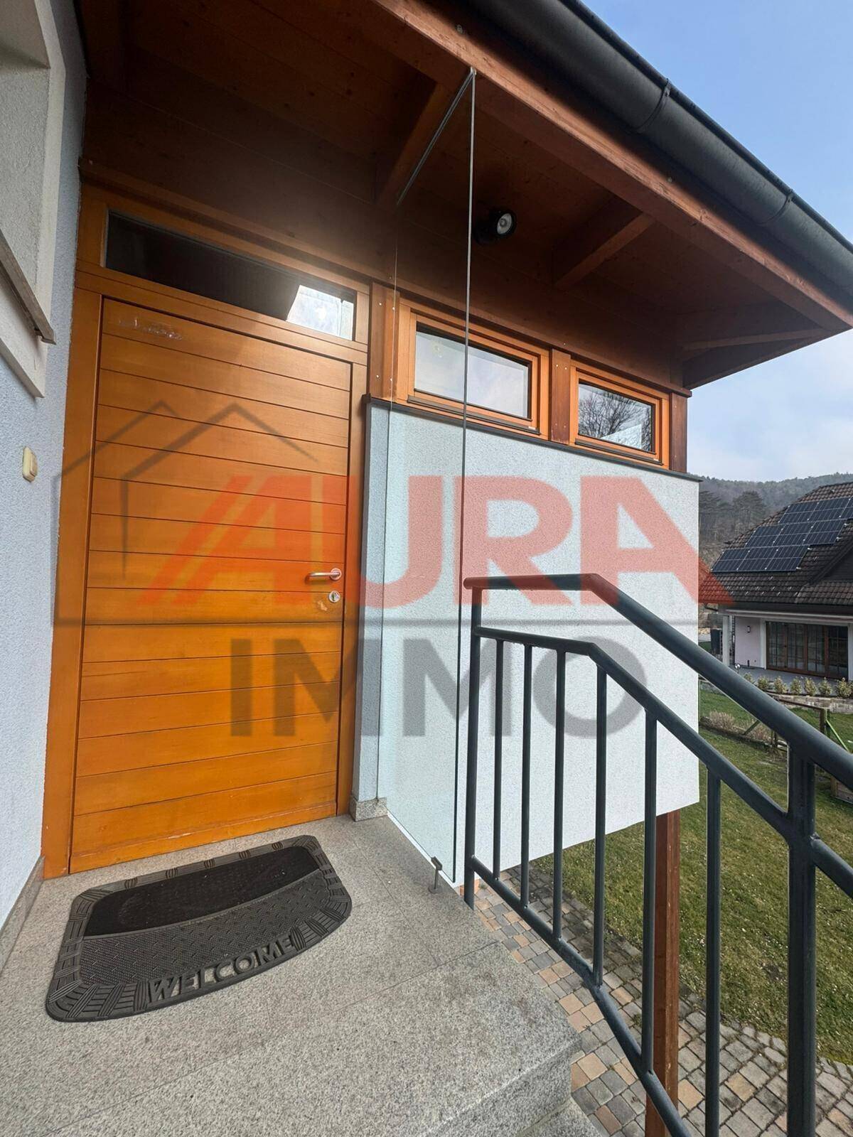 Eingangsbereich des Hauses mit Holztür und Treppe, einladend und funktional gestaltet.