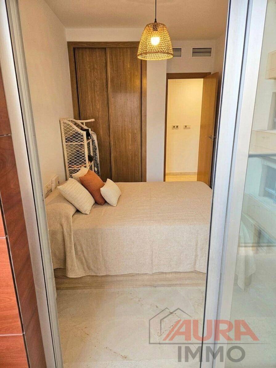 Schlafzimmer mit Doppelbett, Einbauschrank und Zugang zu einem weiteren Raum.