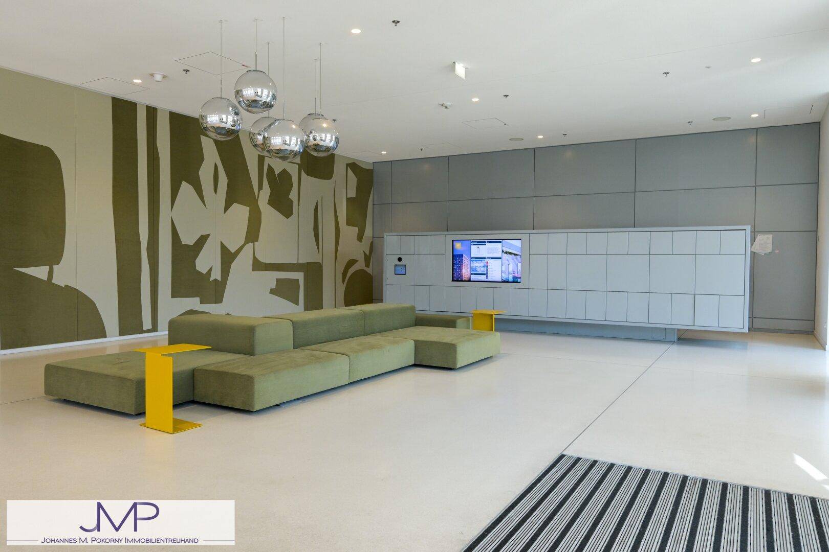 Moderne Lobby mit bequemen Sitzgelegenheiten, Schließfächern und dekorativen Lampen.
