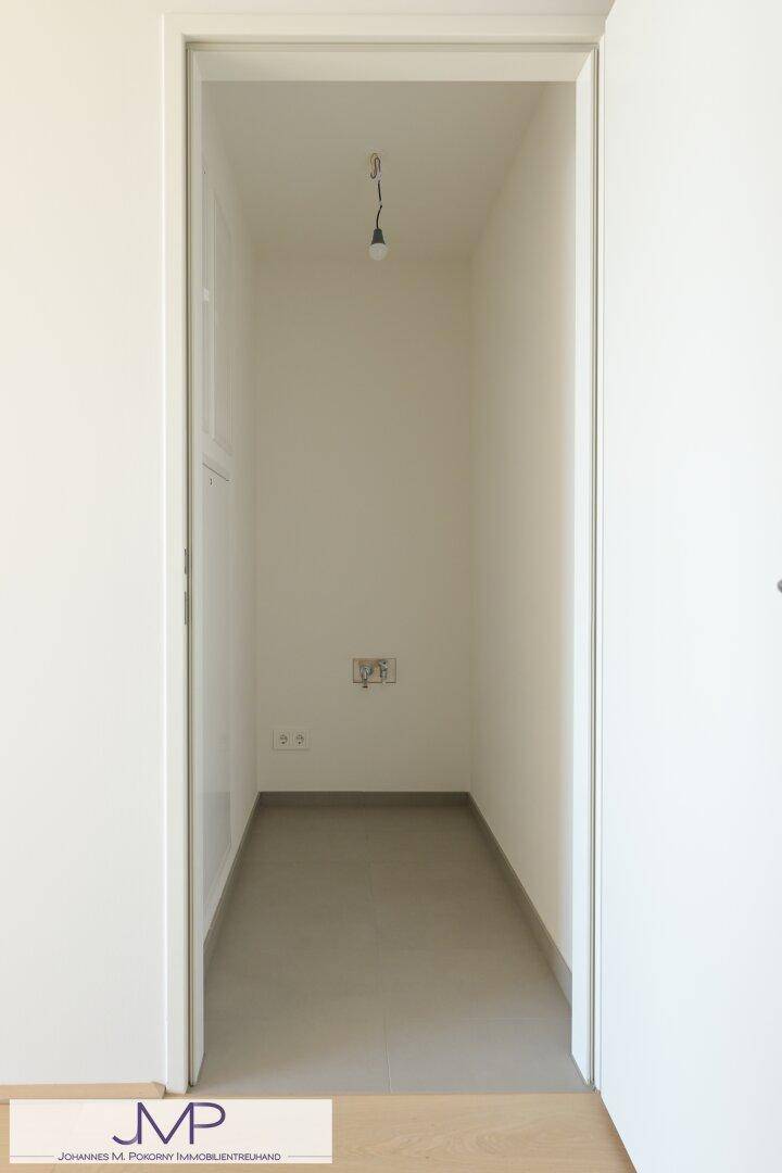 Leerer Abstellraum mit Fliesenboden und weißen Wänden, ideal für Lagerzwecke.