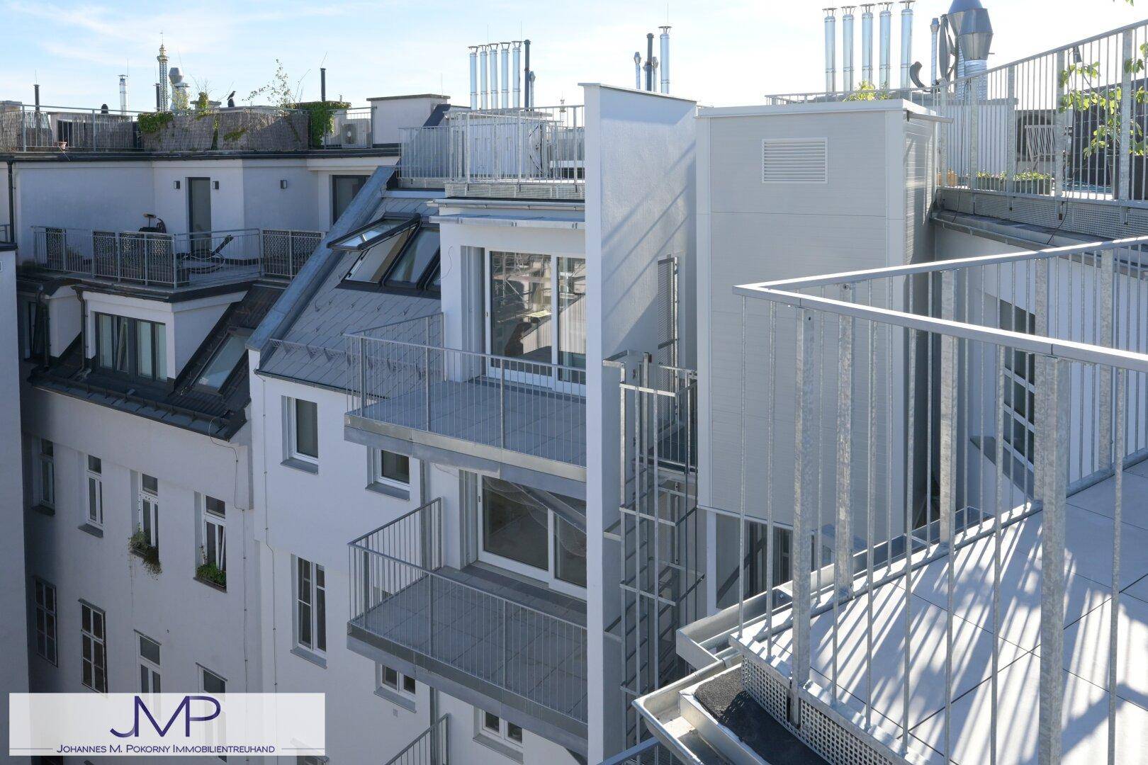 Moderne Architektur des Gebäudes mit mehreren Balkonen und Dachterrassen.