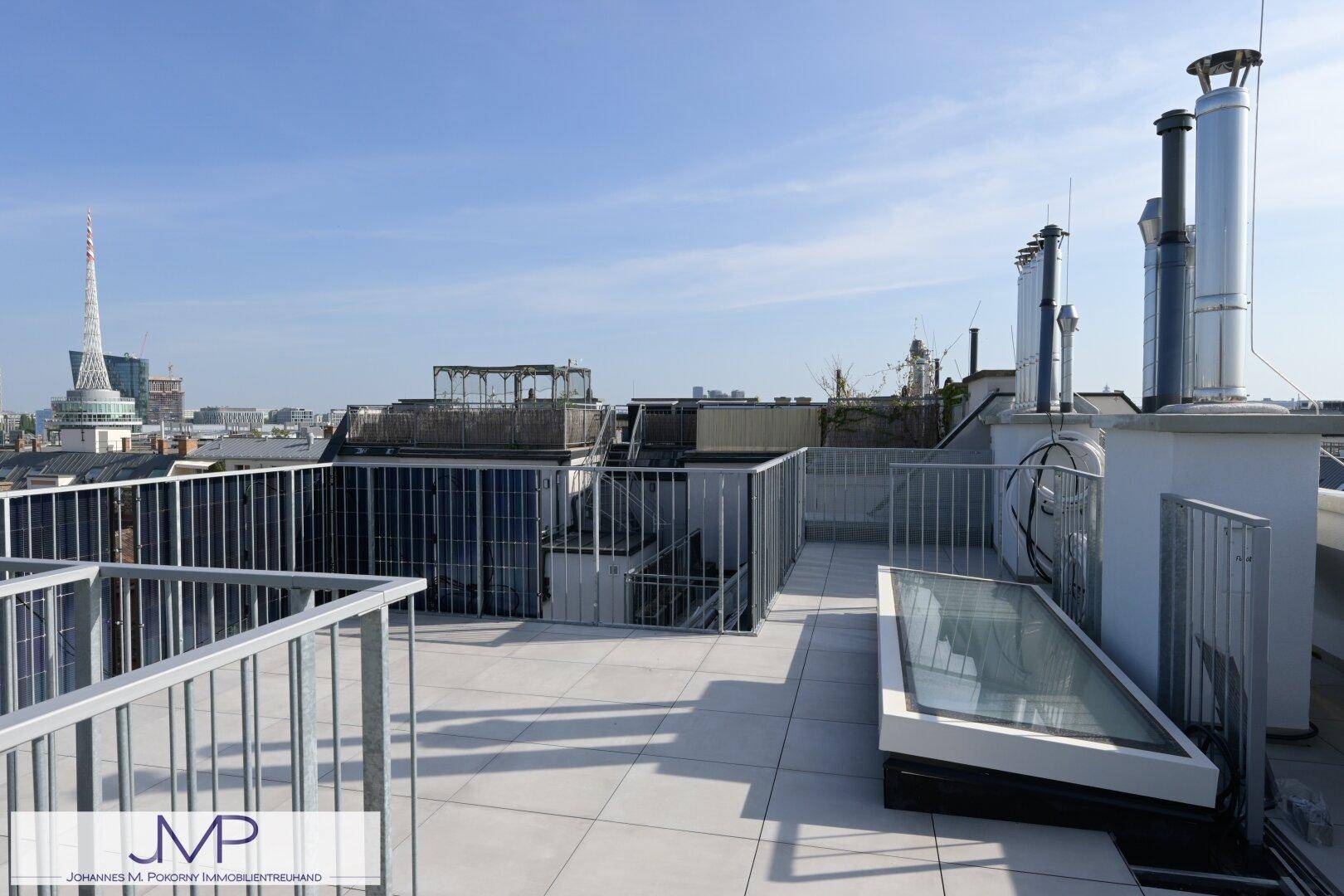 Weitläufige Dachterrasse mit moderner Brüstung und Panoramablick auf die Stadt.