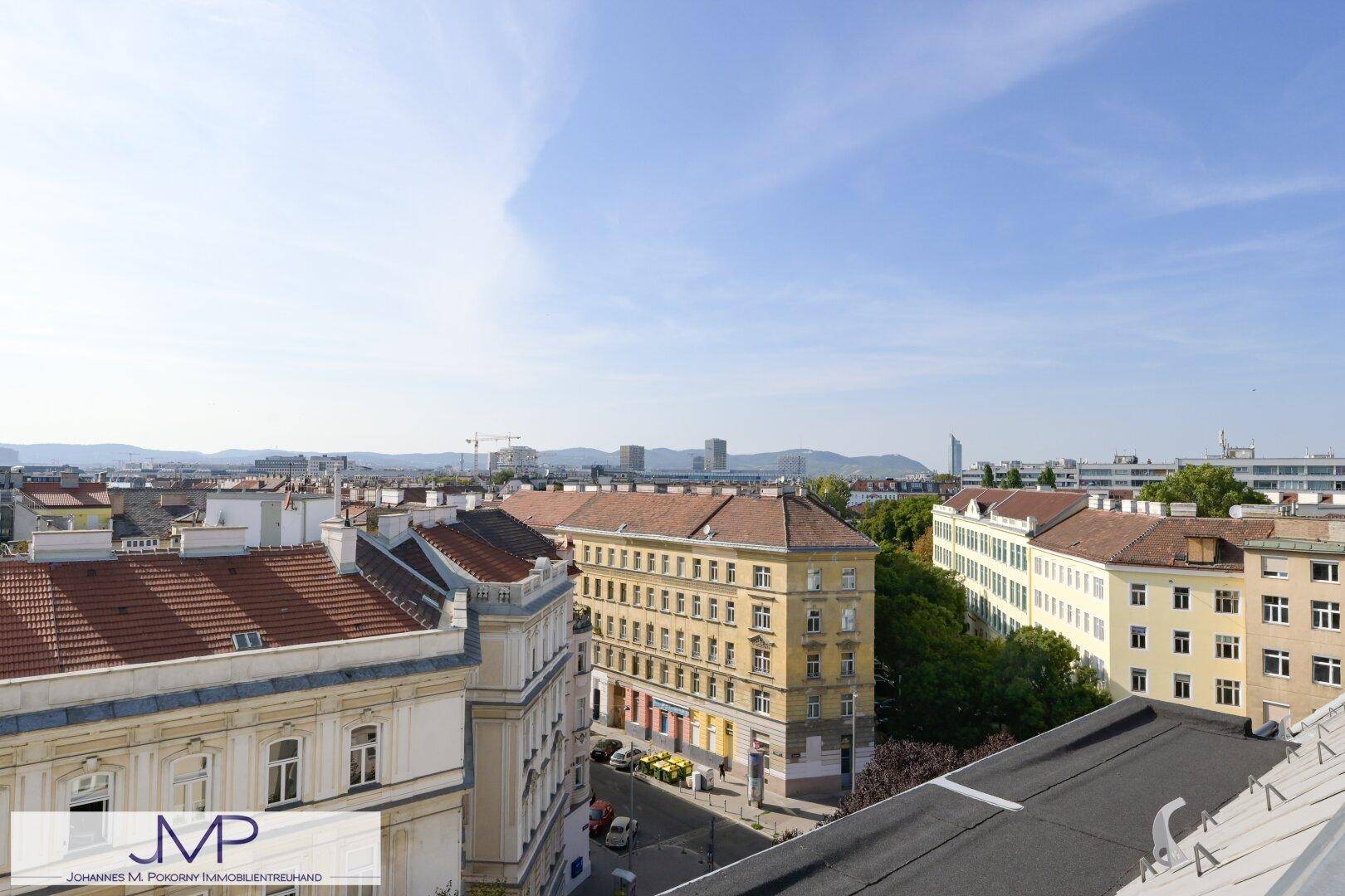 Panoramablick über die Stadt mit historischen und modernen Gebäuden unter blauem Himmel.