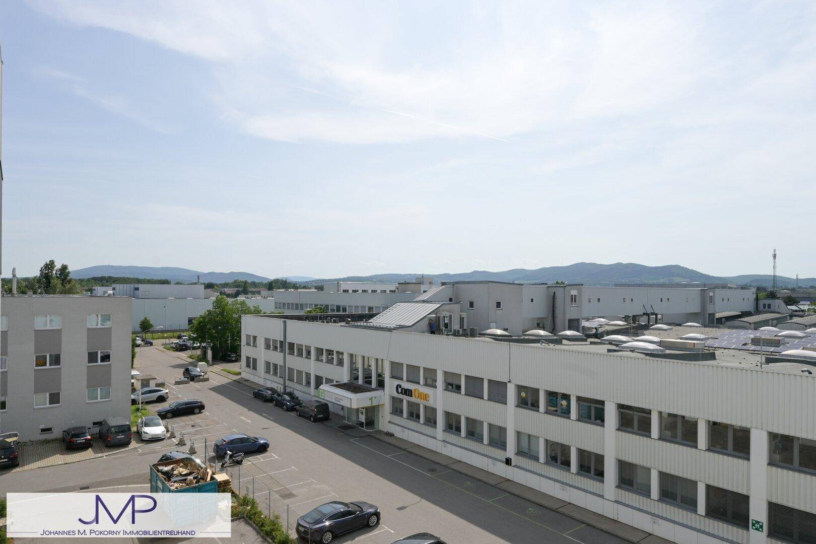 Weitläufige Ansicht eines Industriegebiets mit mehreren Geschäftsgebäuden und Parkplätzen.