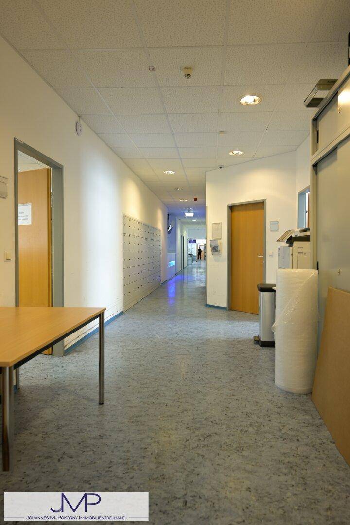 Heller Flur mit Schließfächern an der Wand und Türen zu verschiedenen Räumen.