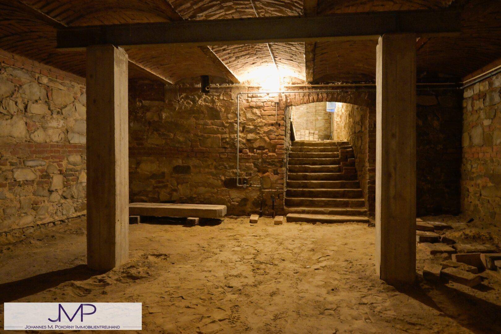 Historischer Gewölbekeller mit robusten Steinmauern und einem Erdboden, der viel Stauraum bietet.