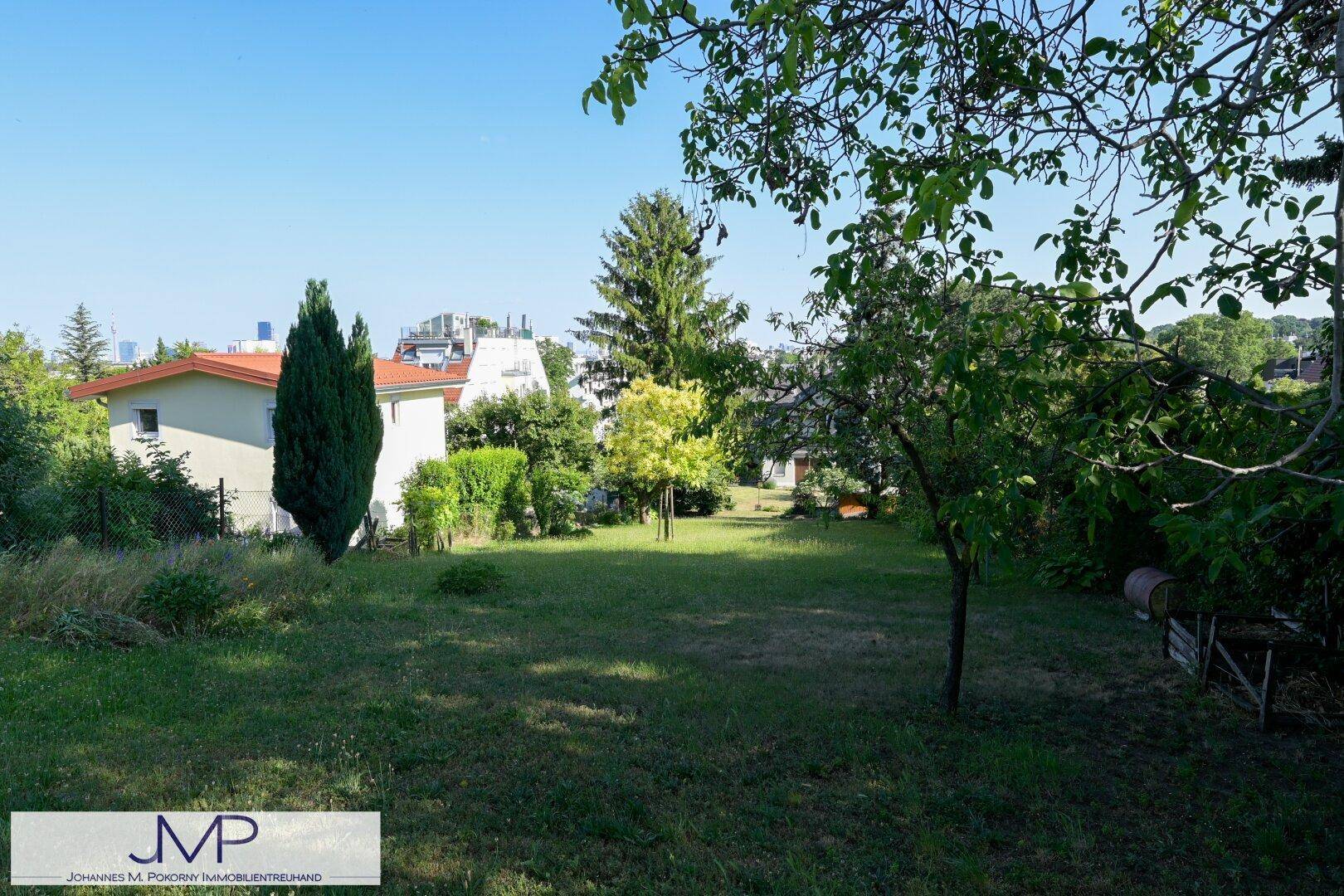 Großer Garten mit viel Grün, Bäumen und einem weiten Blick in die Landschaft.