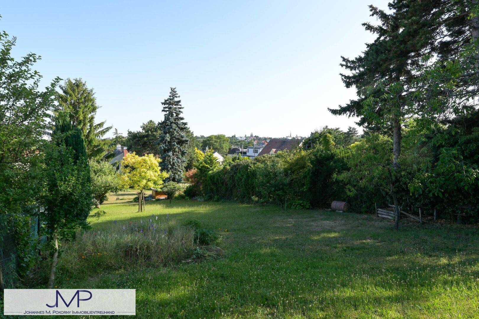 Weitläufiger Garten mit Rasen, Bäumen und einem Panoramablick über die Umgebung.