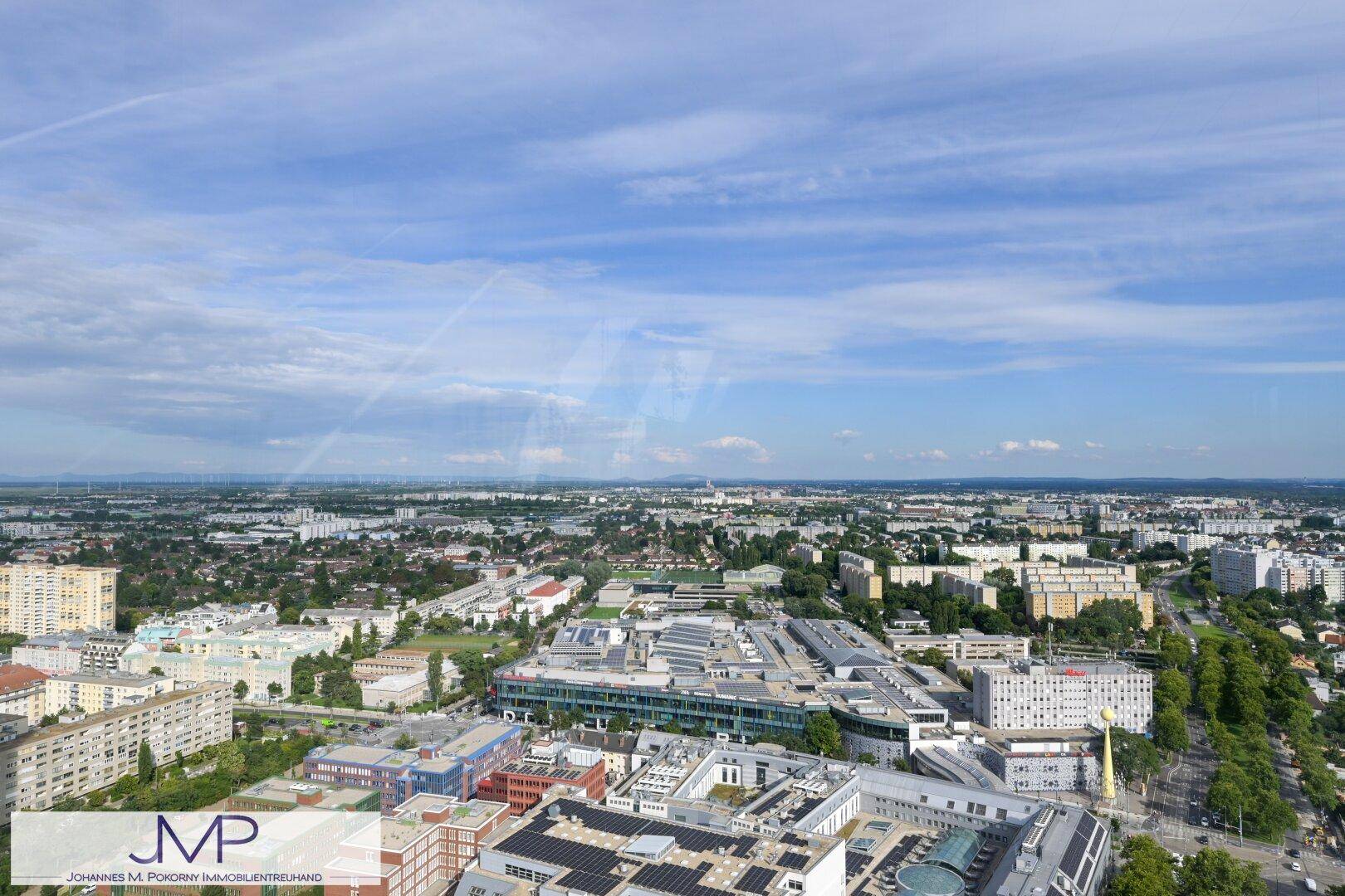 Weitläufiger Blick über die städtische Bebauung und die Vororte unter blauem Himmel.