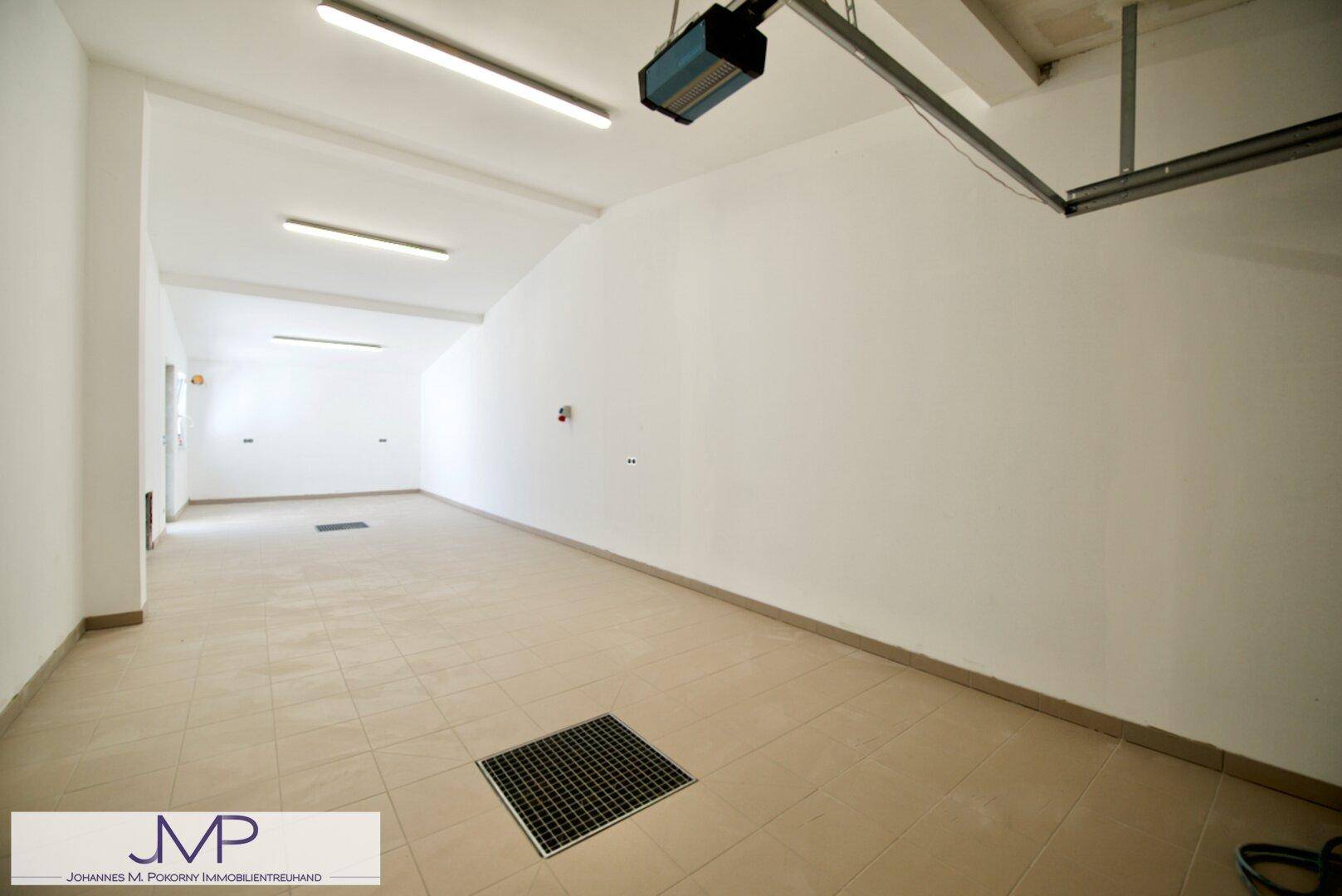 Geräumige und helle Garage mit Fliesenboden und ausreichend Platz für Fahrzeuge.