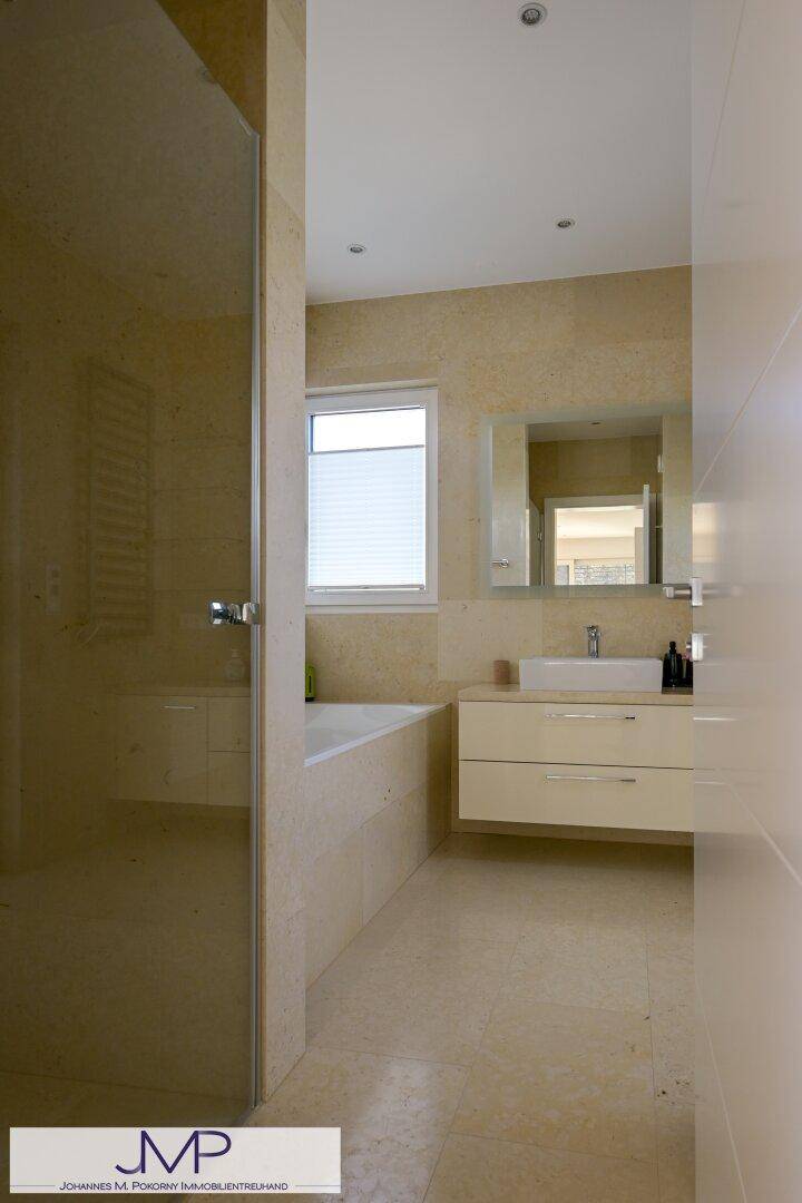 Elegantes Badezimmer mit begehbarer Dusche, integrierter Badewanne und modernem Waschtisch.